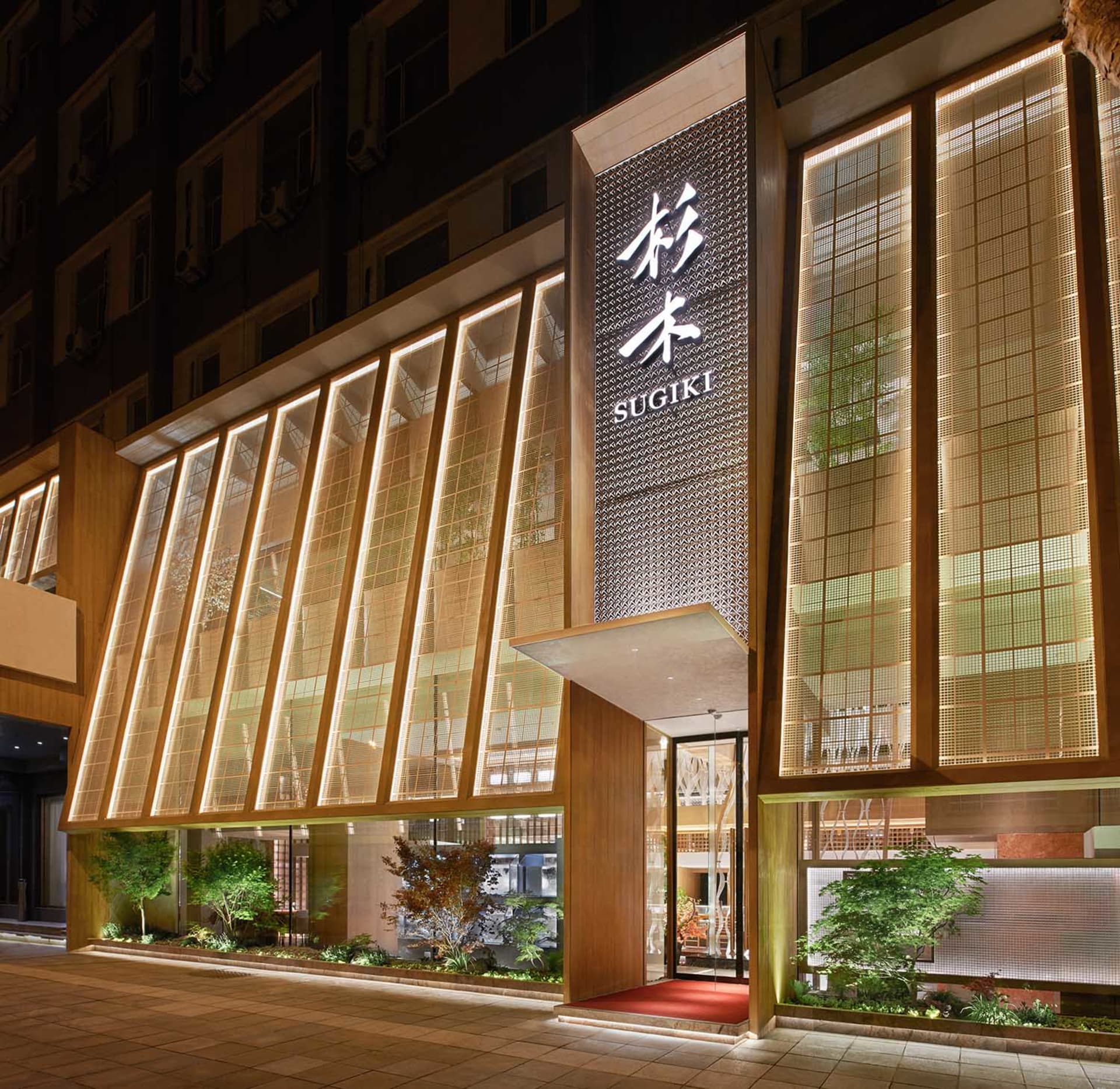 現代亞洲餐廳，紅地毯、盆栽與溫暖燈光