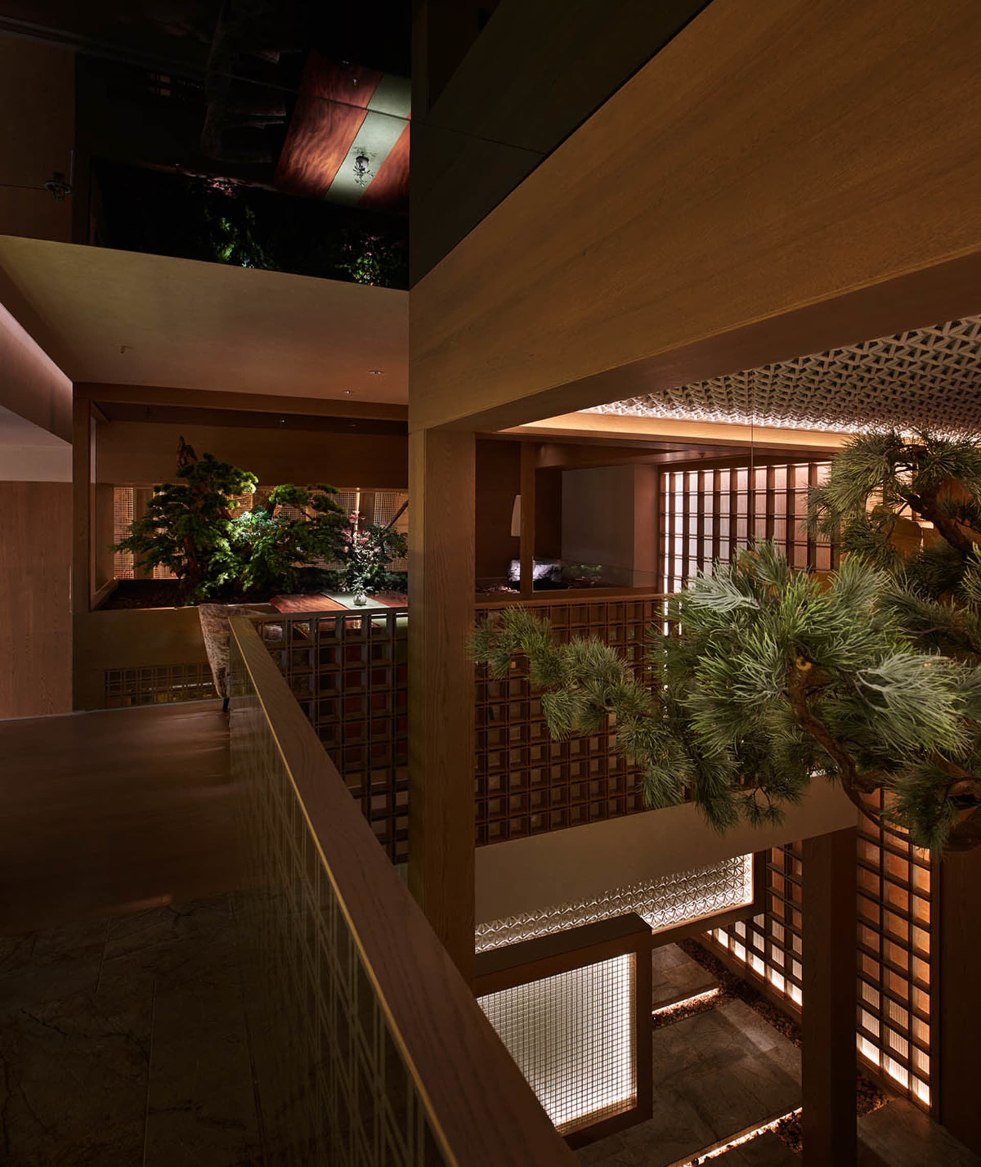 A warm and inviting staircase with wooden stairs and railing, surrounded by two potted plants adding a touch of greenery to the space