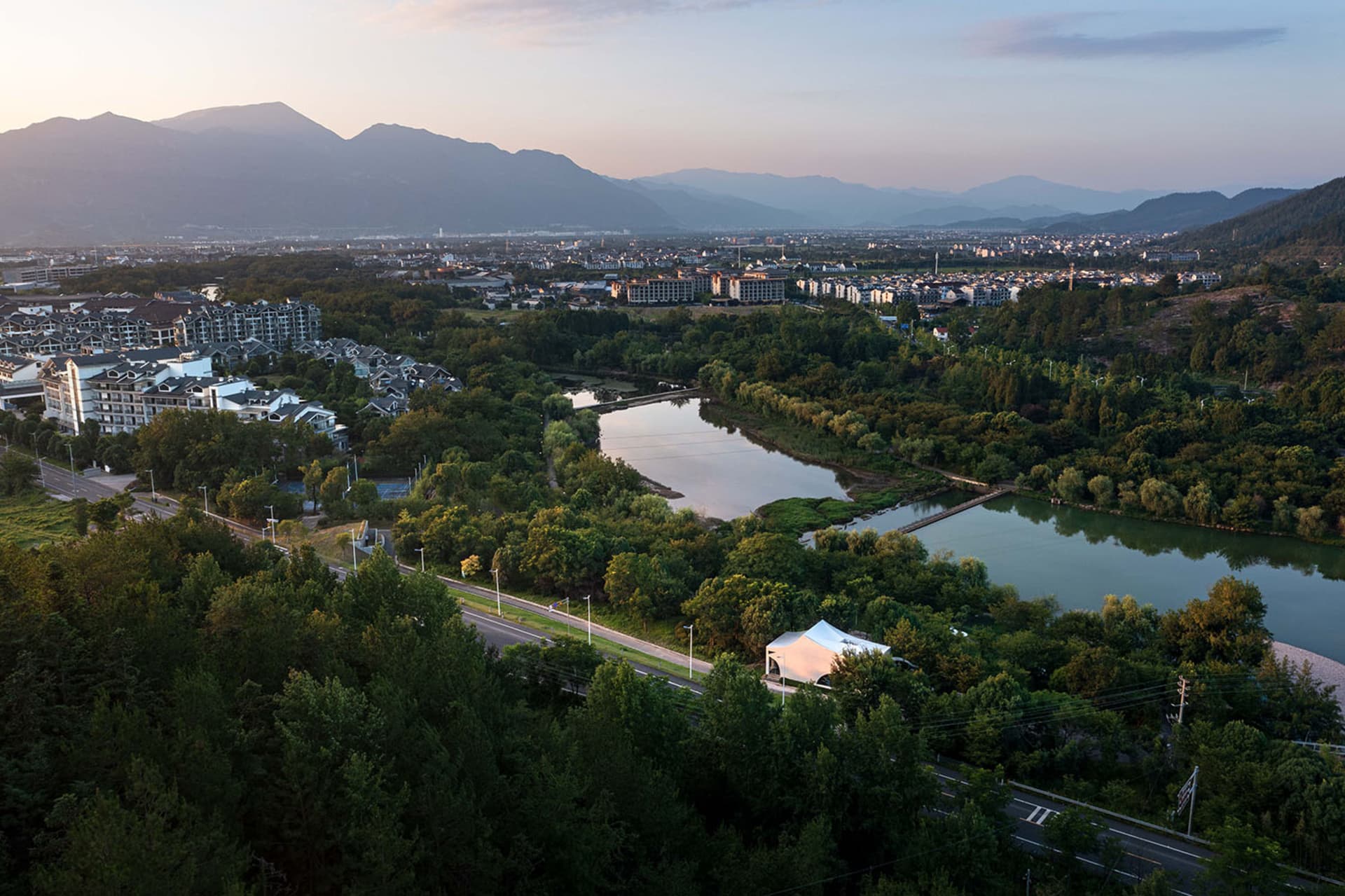 寧靜的城市景觀，大片水域位於建築物前方，周圍環繞多棟建築，氛圍平靜安詳