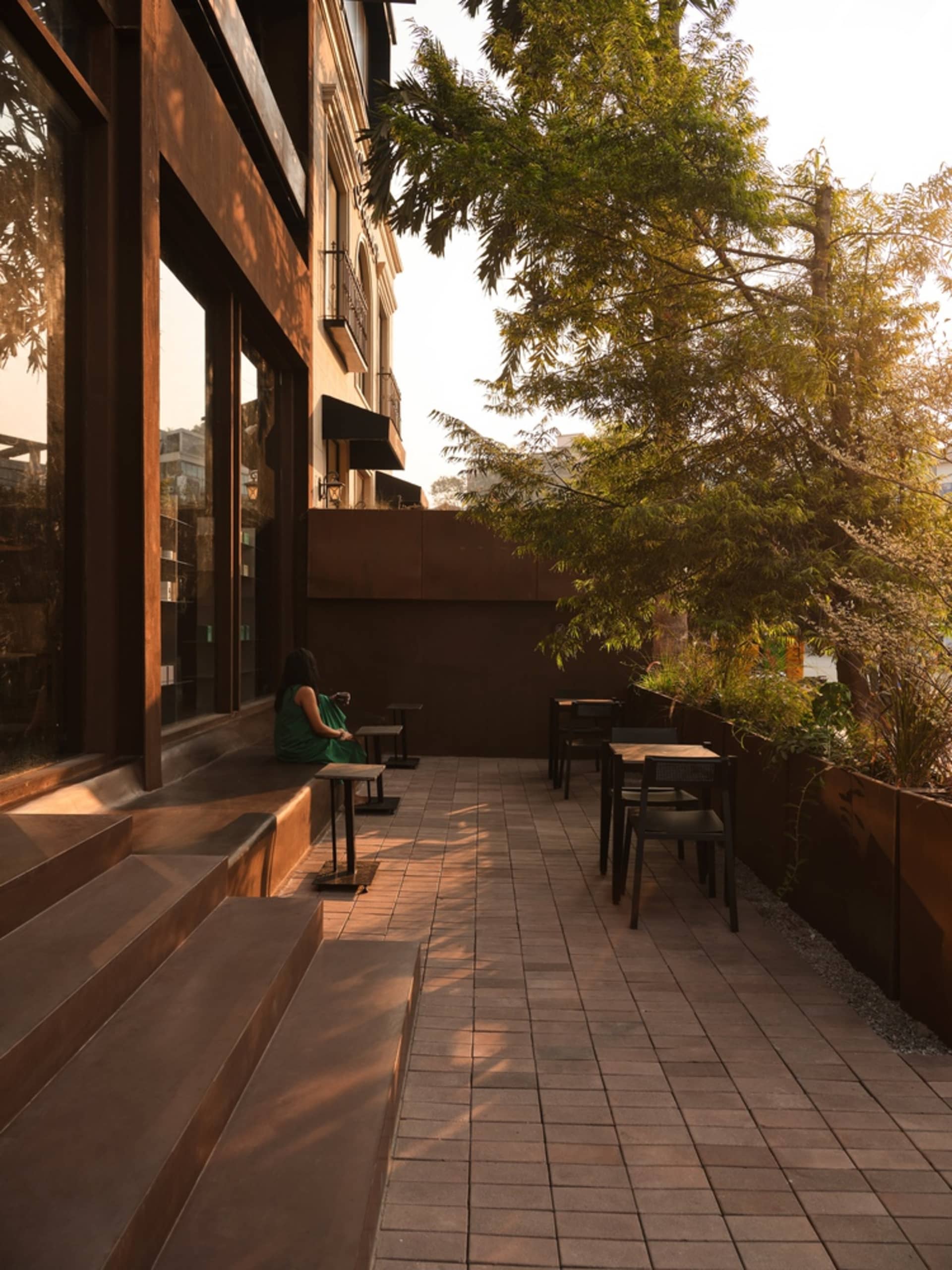 A restaurant patio with wooden benches, tables, and chairs, set in a comfortable and inviting atmosphere