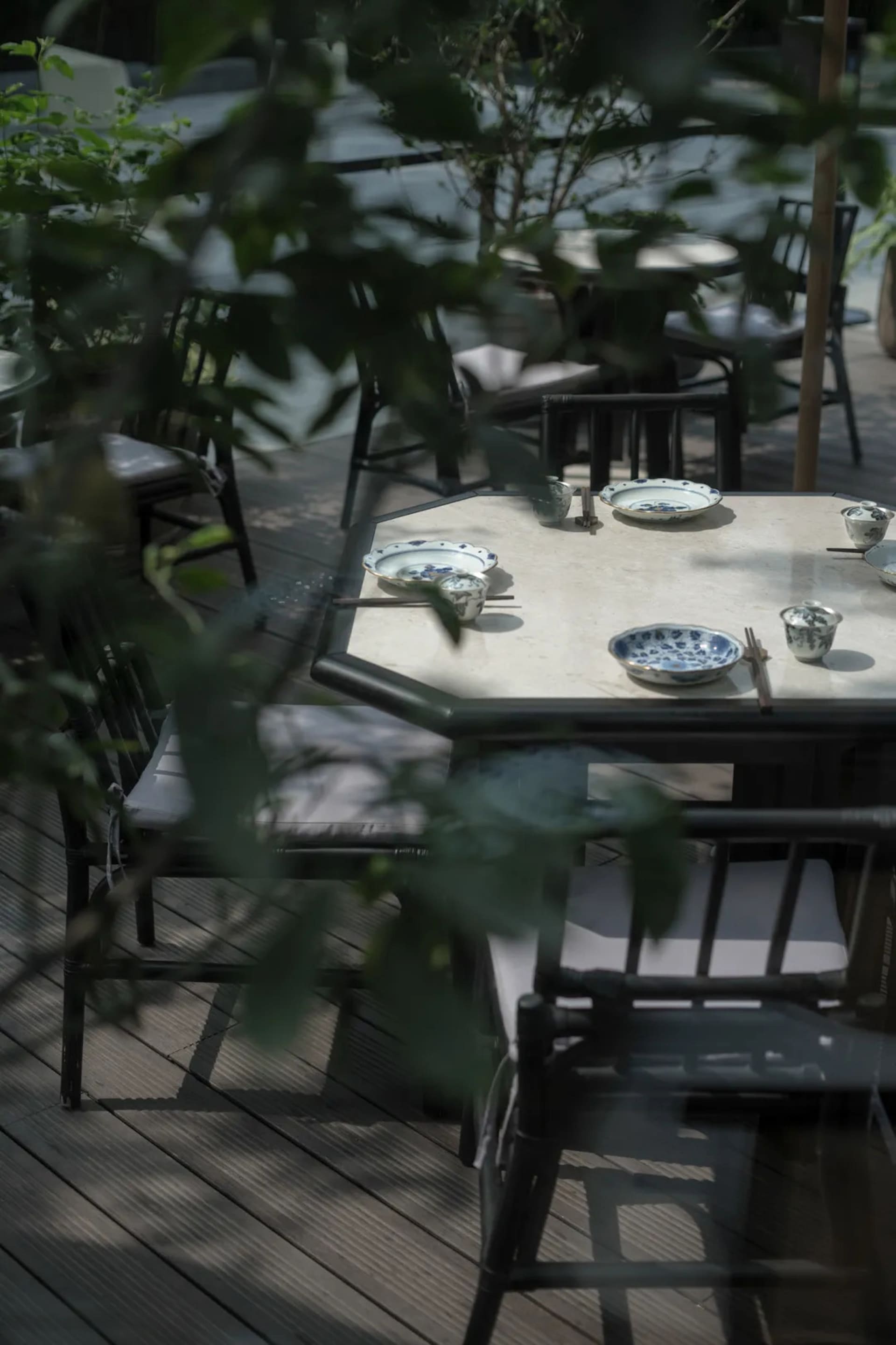 Casual outdoor dining area with wooden tables and chairs, featuring bowls for serving food in a relaxed environment