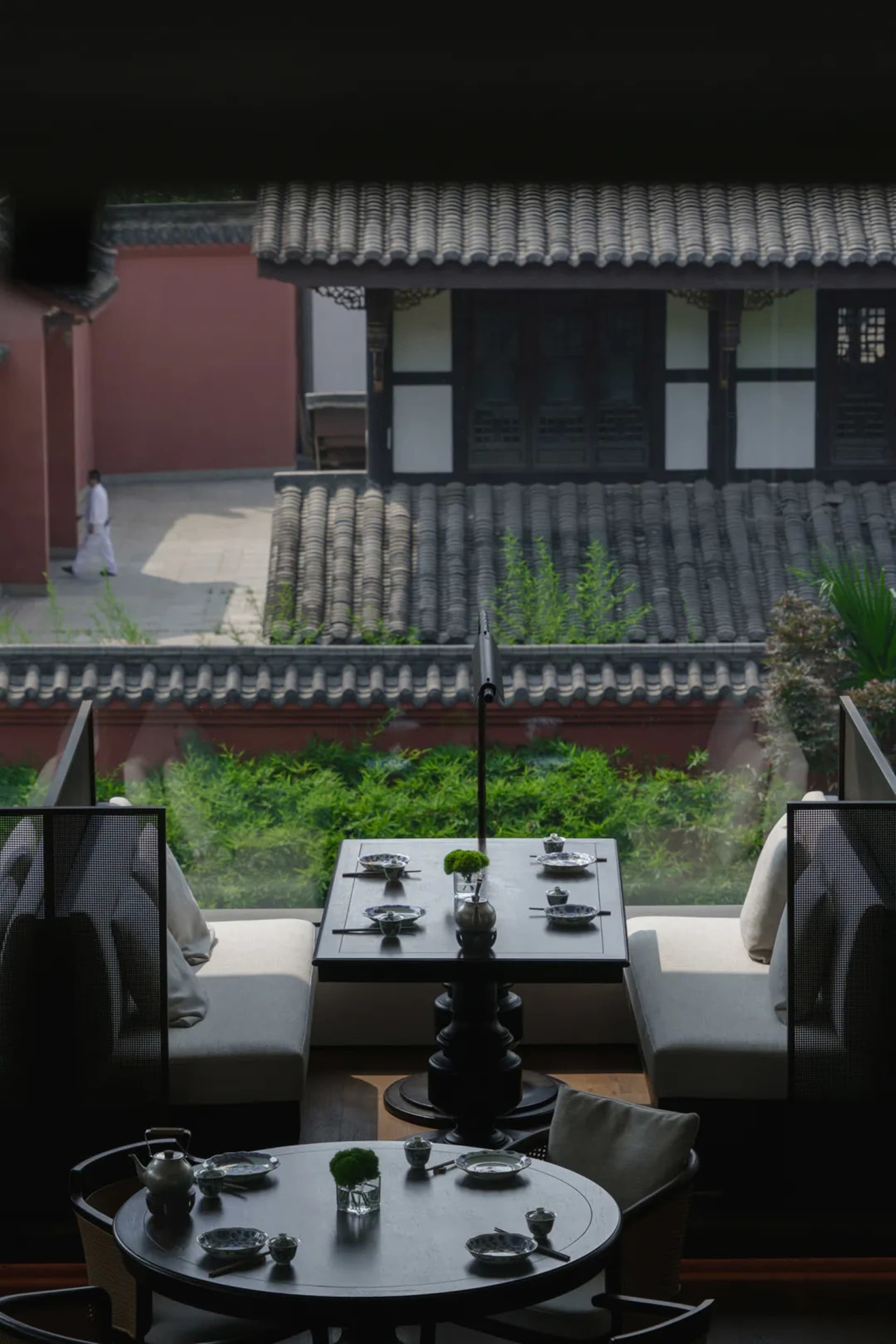溫馨亞洲餐廳，設有大型餐桌、紅牆與瓦頂，準備就餐