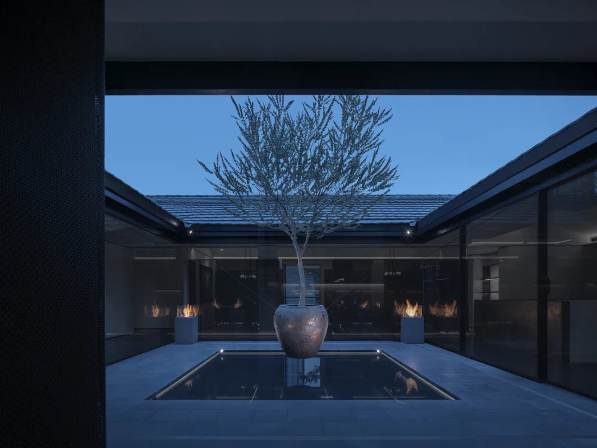 A modern living space with a large tree in a vase on a stone floor, surrounded by chairs and potted plants, with a stylish ambiance created by artificial lighting