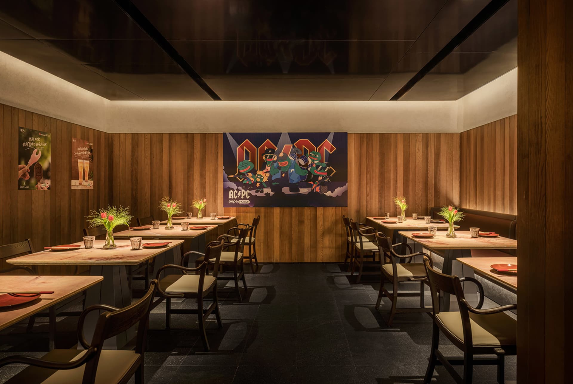 Dimly lit restaurant with wooden walls, tables, and chairs, creating a cozy atmosphere