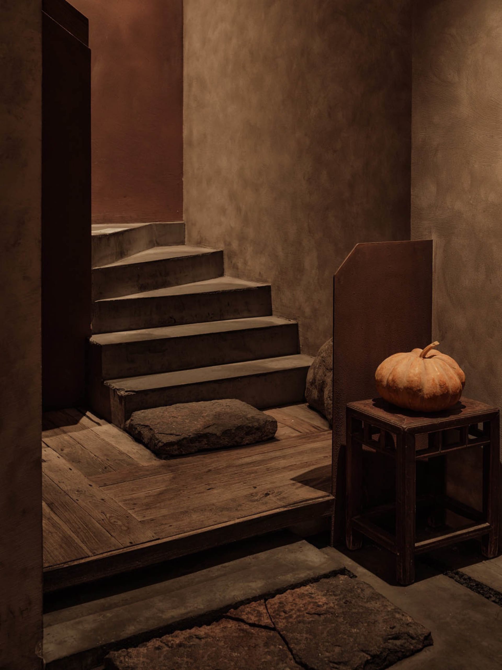 Cozy interior stairwell with a wooden floor, stone steps, and autumn decorations
