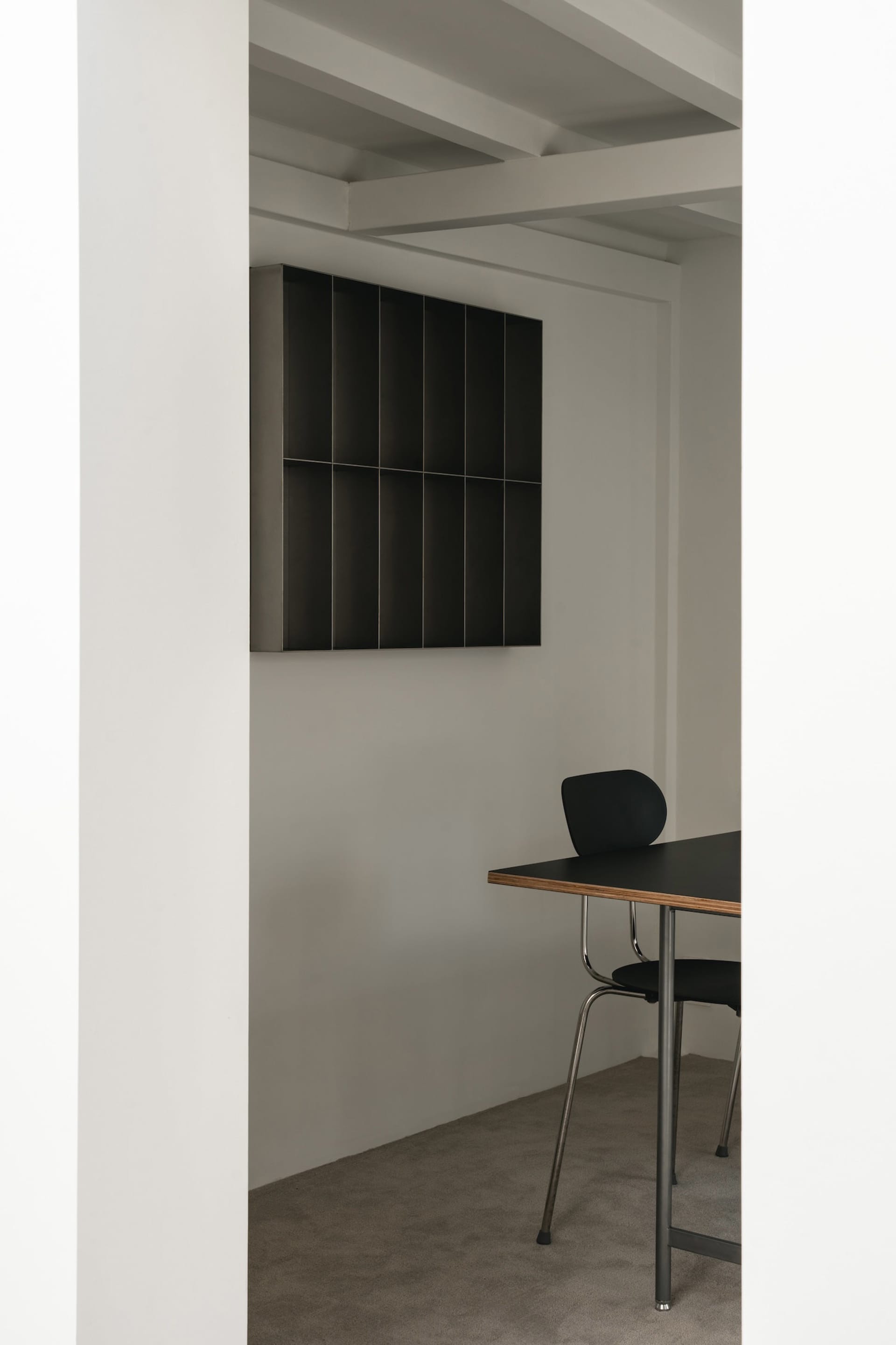 A clean and organized office space with a black desk, two chairs, and a cup, set against a white background