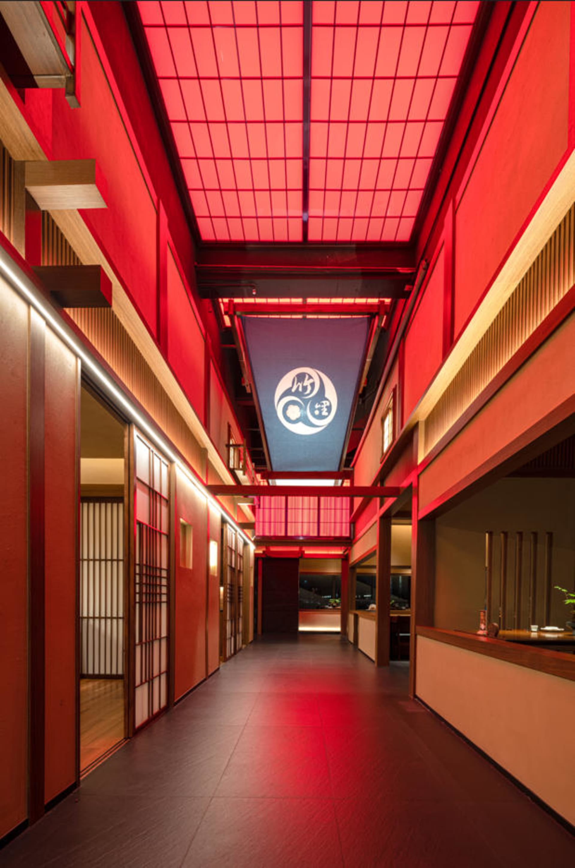 A warm and inviting hallway with red walls, wooden floors, and natural light from several windows