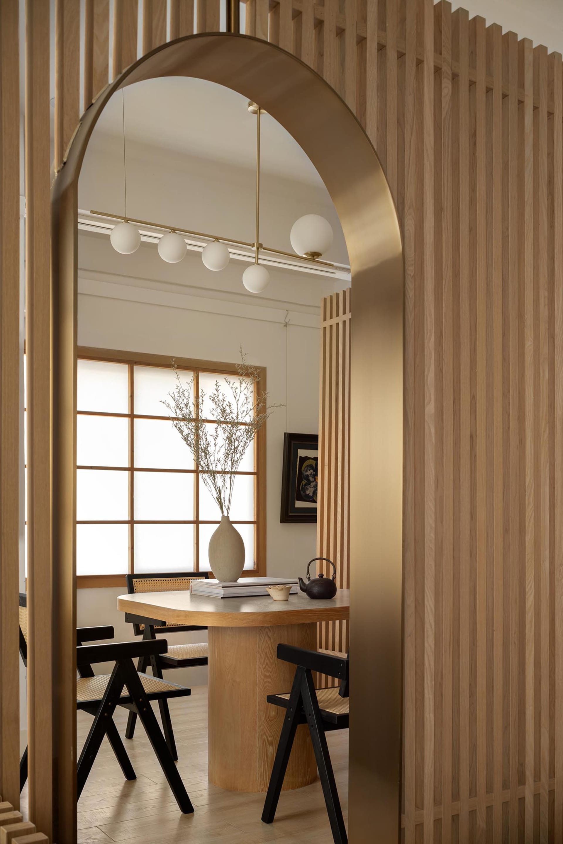 Cozy living space with wooden walls and floors, multiple chairs, benches, and a dining table, with a vase adding a decorative touch