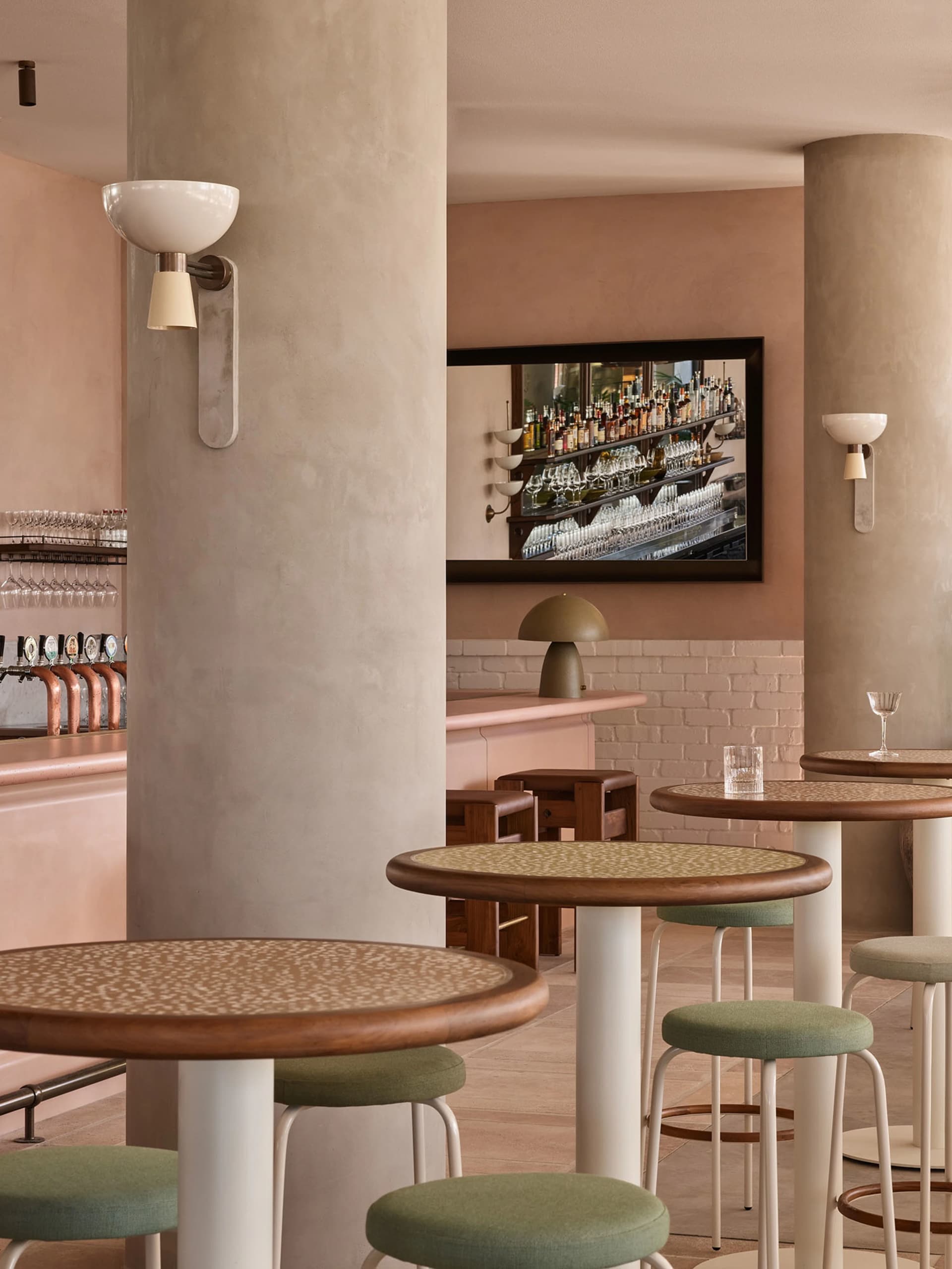 A cozy bar area with wooden tables and chairs, wine glasses, and various seating options