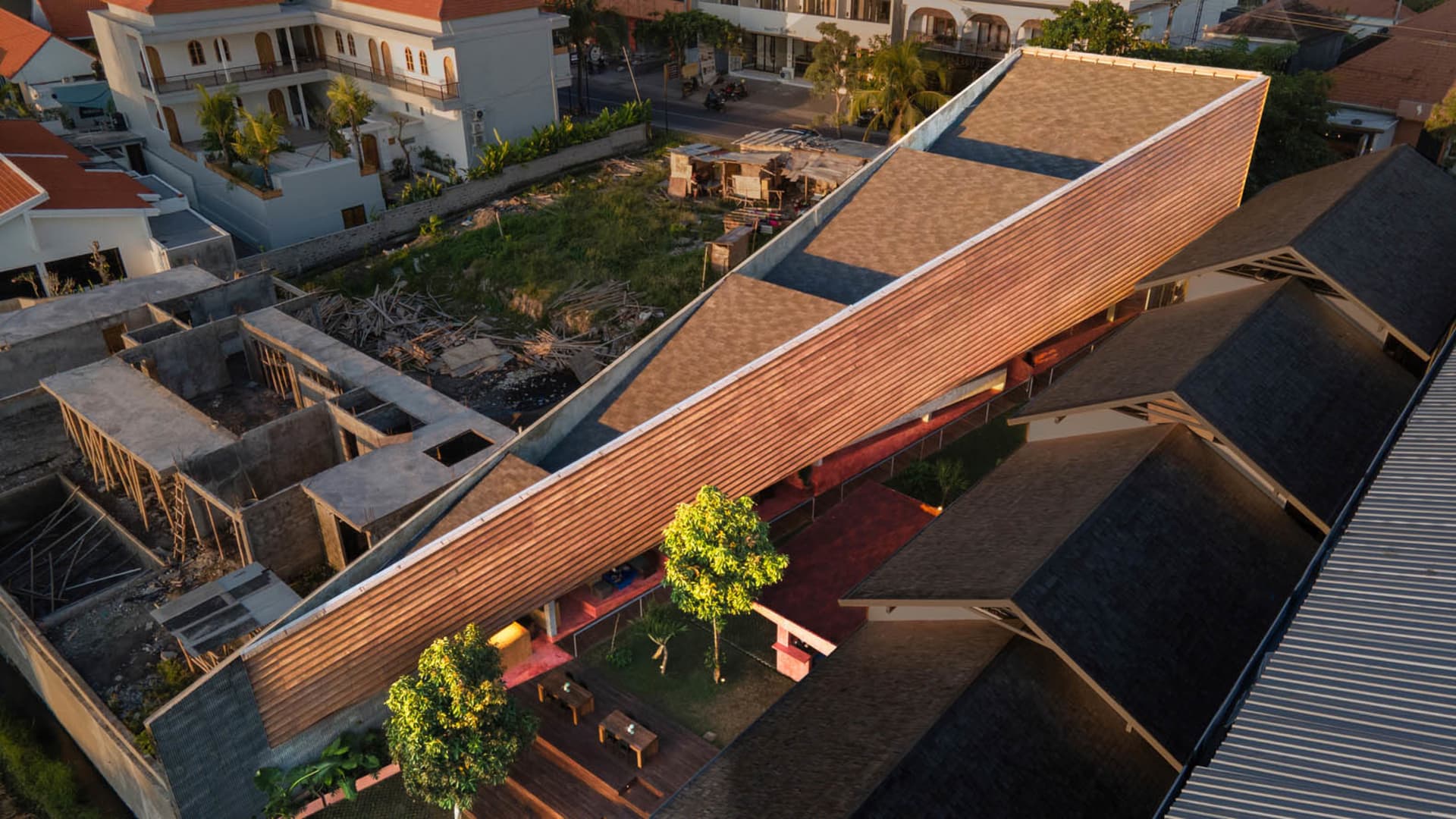 A rustic wooden house with a red roof, surrounded by benches and a relaxed atmosphere