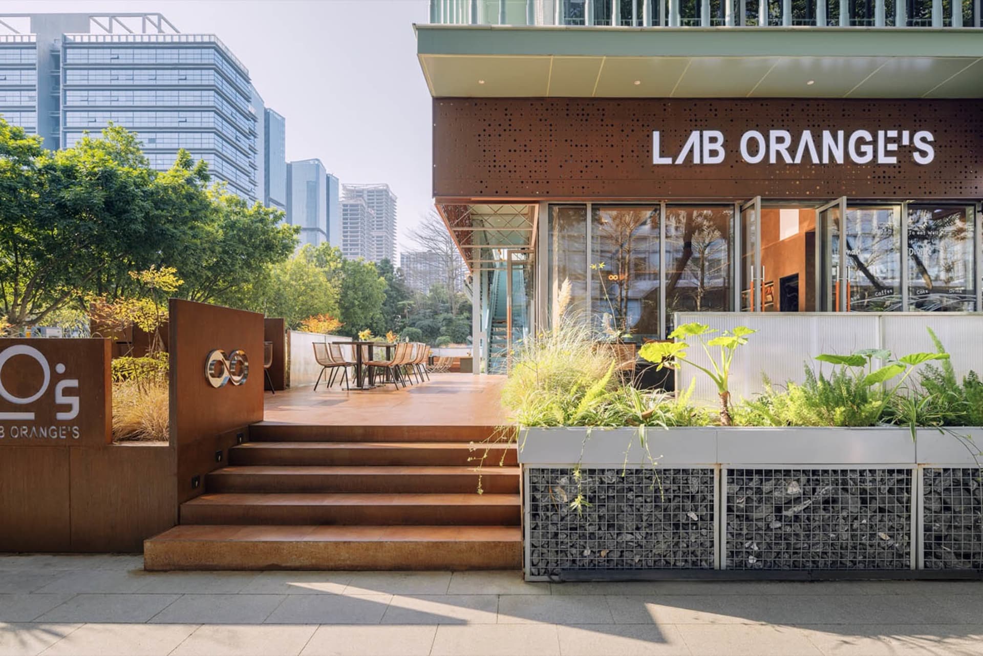一座現代建築的外觀設有寬敞露台區域，配有多張椅子與餐桌，為賓客營造溫馨氛圍，盡情享受用餐樂趣