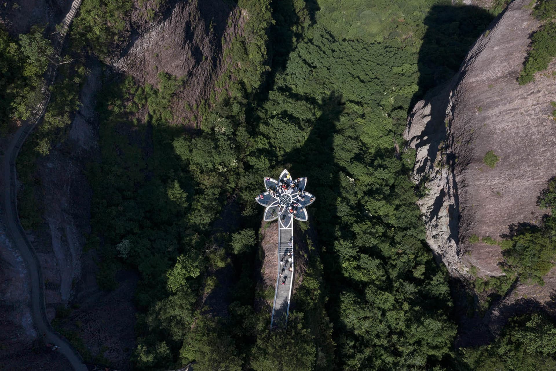 山側大型建築物的鳥瞰圖，配有圓形鐘塔，周圍環繞樹木與山巒