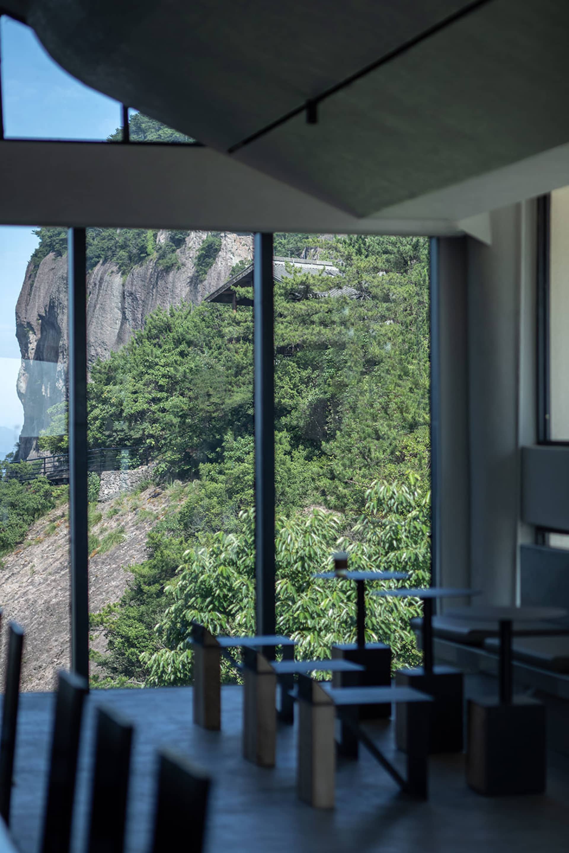現代玻璃牆與木質元素的餐廳，透過大片窗戶遠眺山景