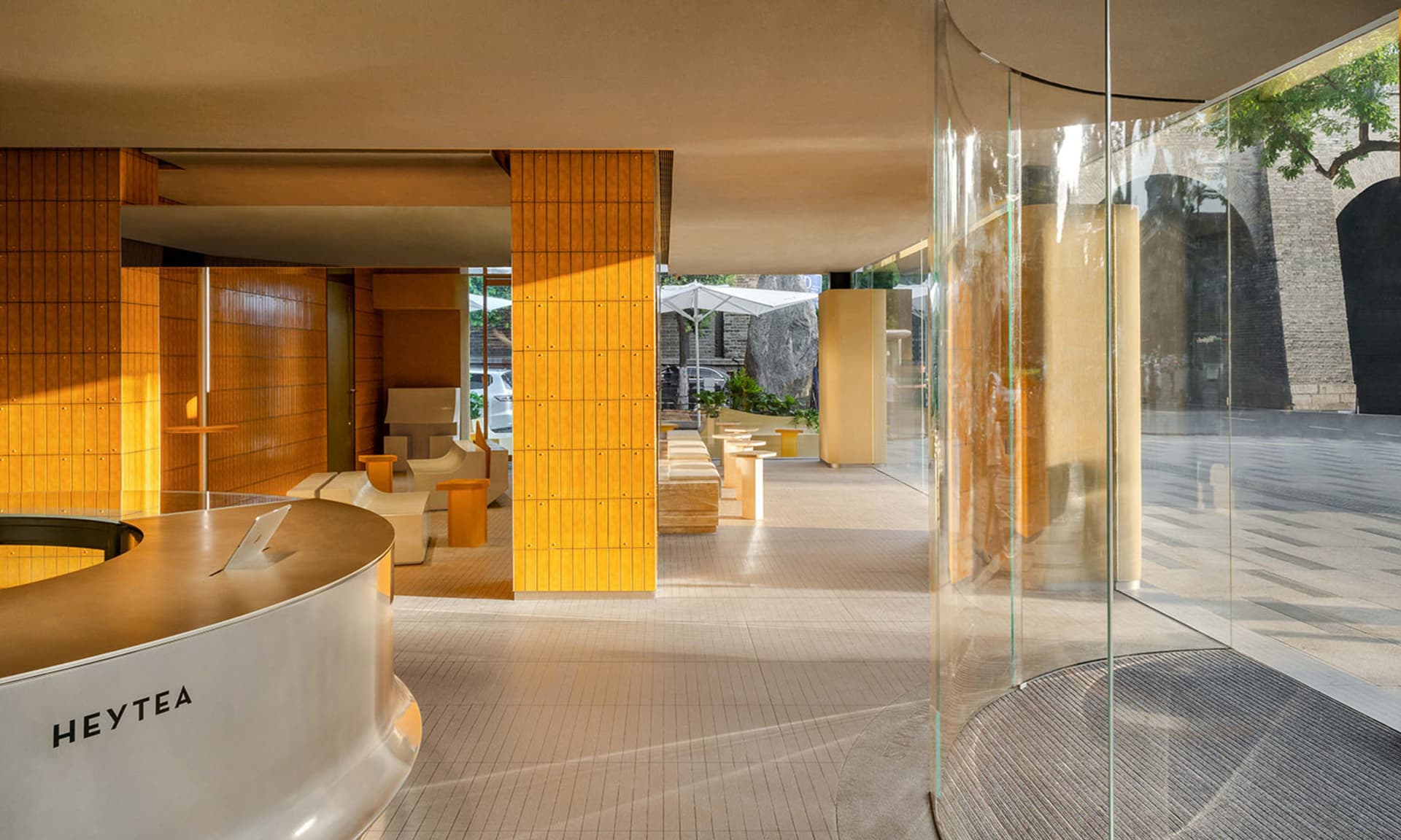 Cozy home interior with a yellow accent wall, glass door, and dining table surrounded by chairs, with a car parked outside