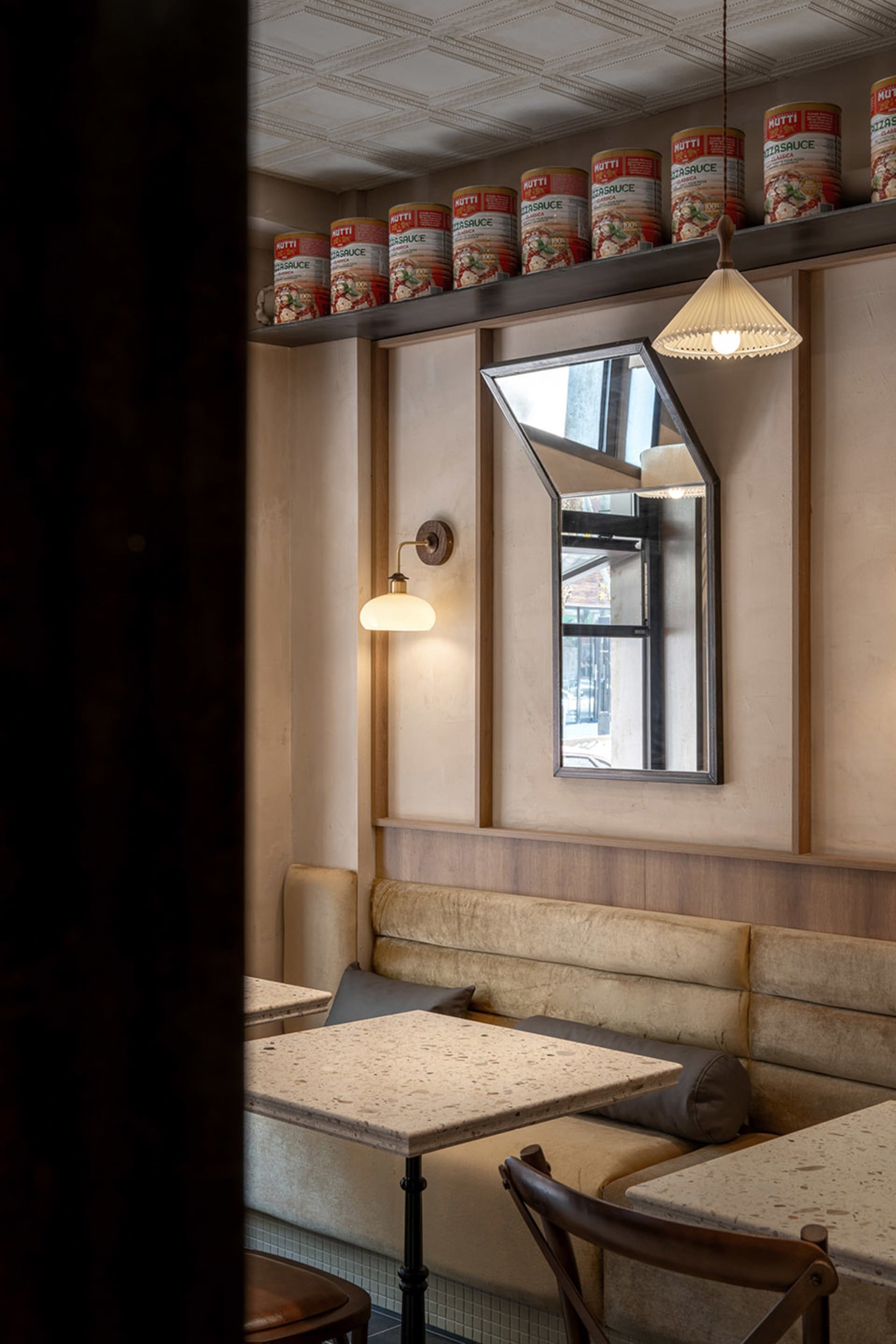 A cozy restaurant dining area with wooden panel walls, tables, and chairs, creating a warm and inviting atmosphere for guests