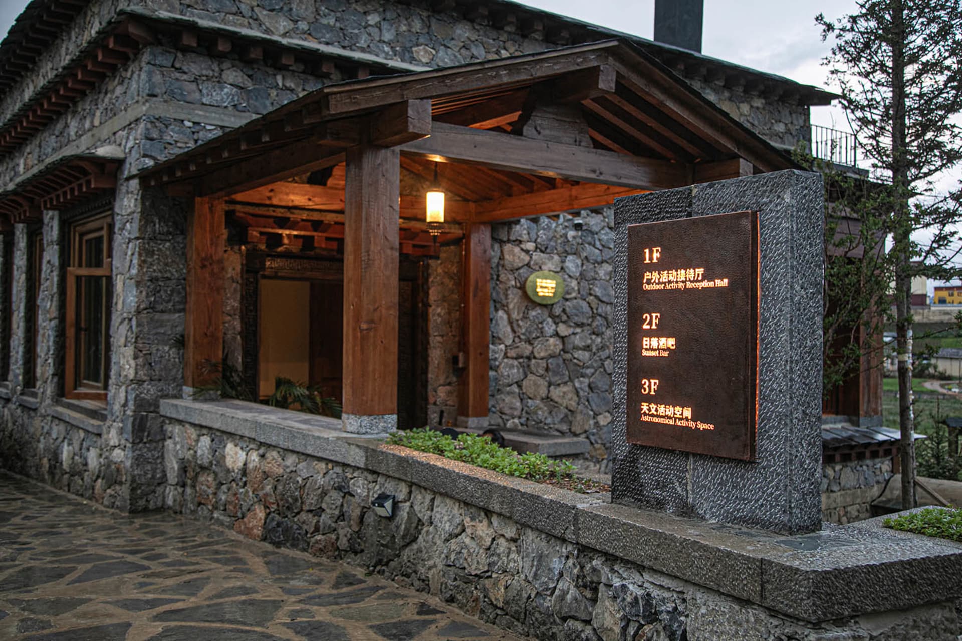 一座石材建築，擁有木結構和大拱門，設有招牌並融合傳統與現代建築元素