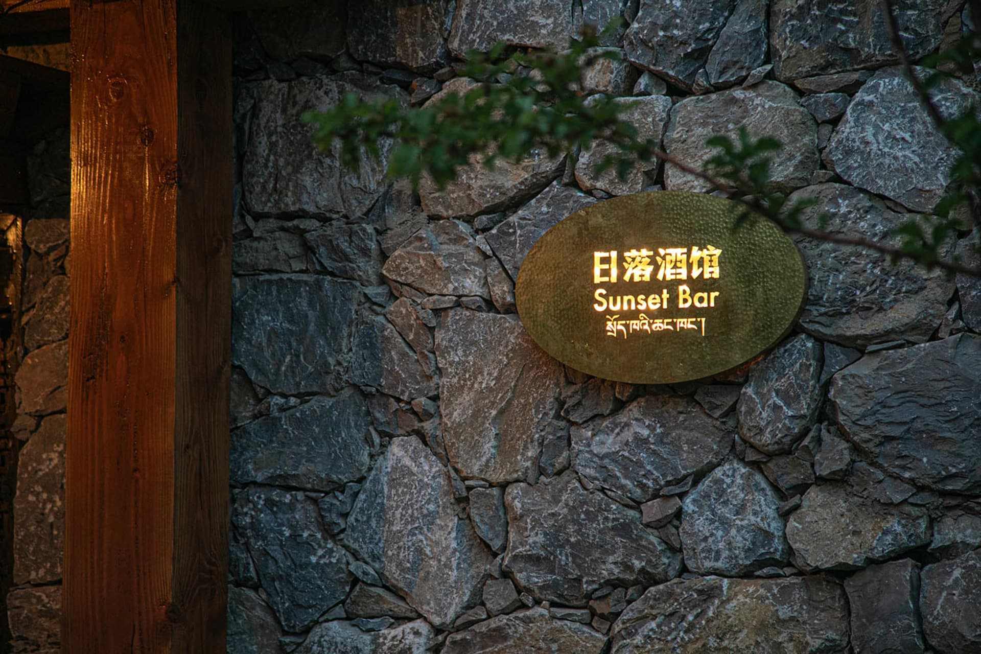 Cozy Asian restaurant with a stone wall, wooden door, and dim lighting
