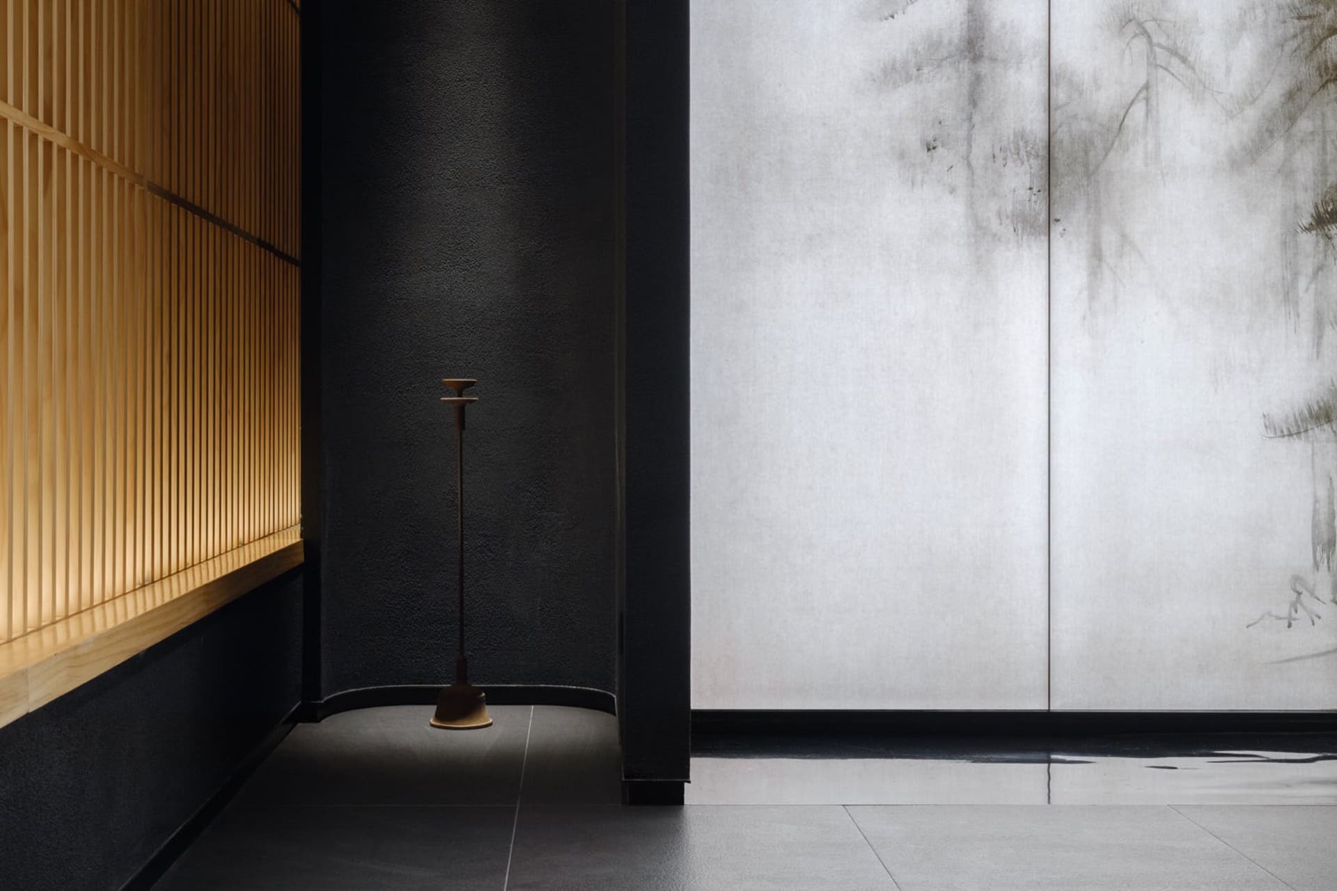 Black walls and grey tiled floor create a calm and inviting modern space with two doors and a contemporary design
