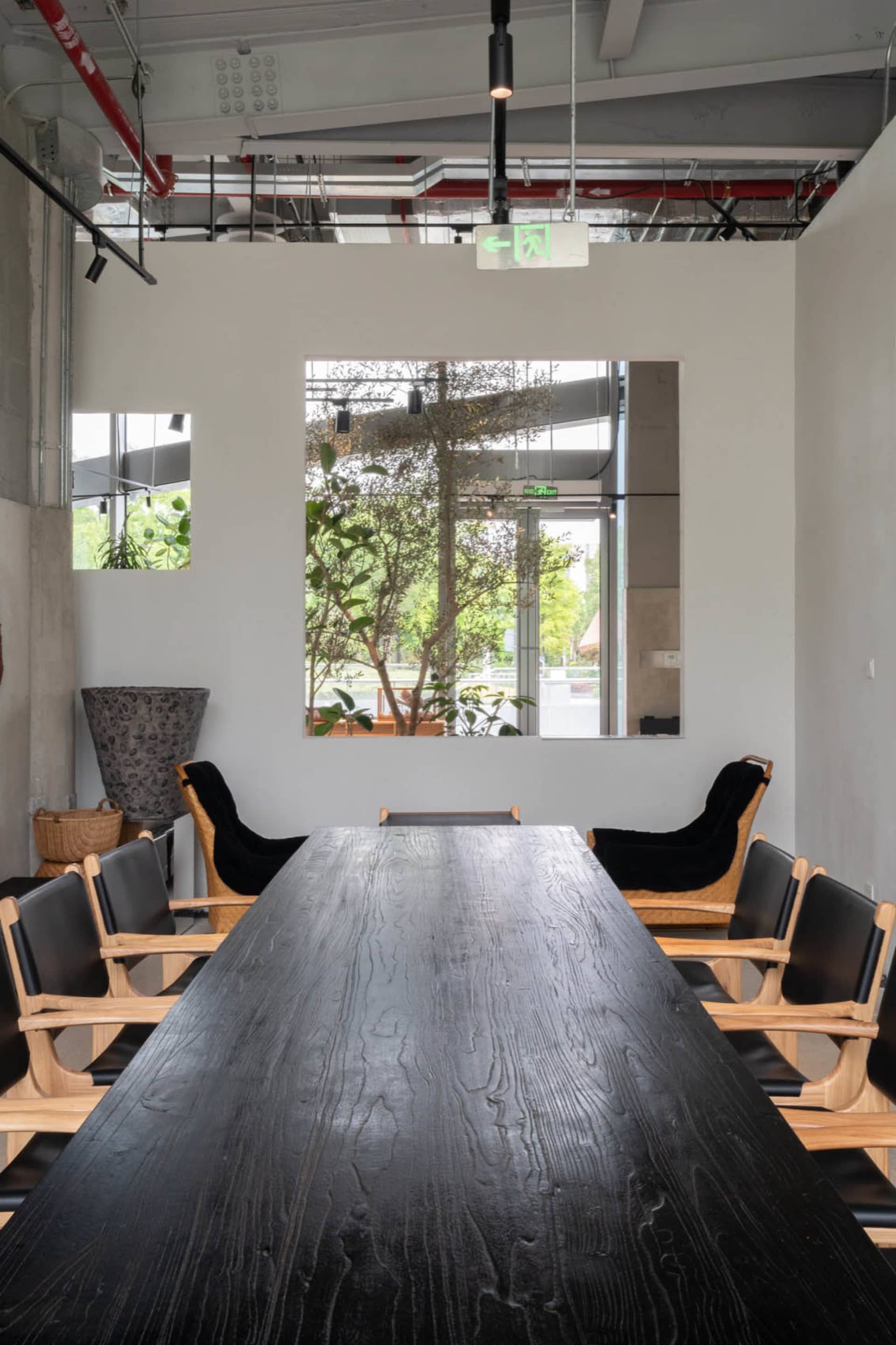A well-lit office space with a large wooden table and several chairs, creating a comfortable atmosphere for work or meetings