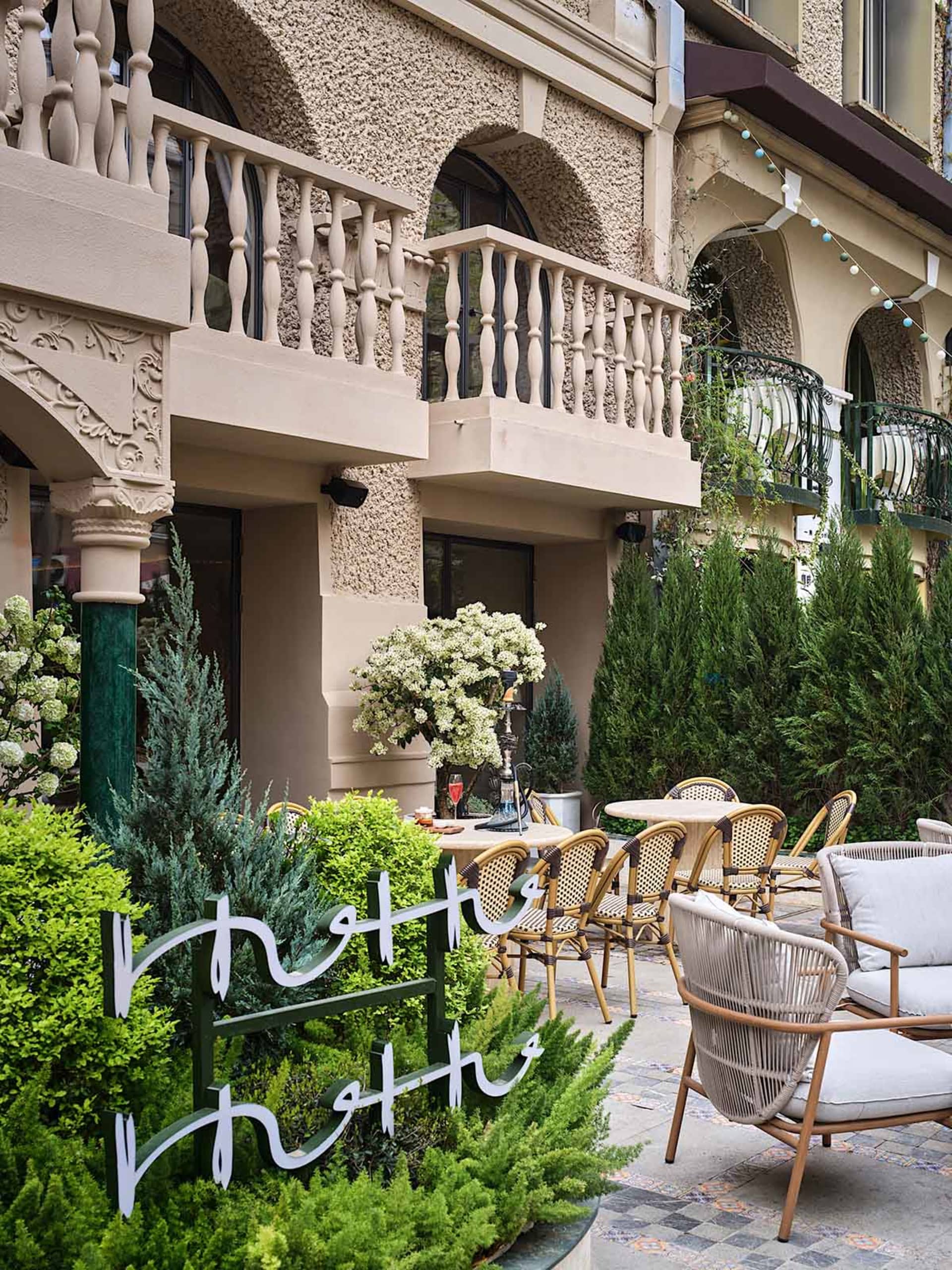A balcony with wicker chairs and potted plants, creating a relaxing outdoor space with a warm atmosphere