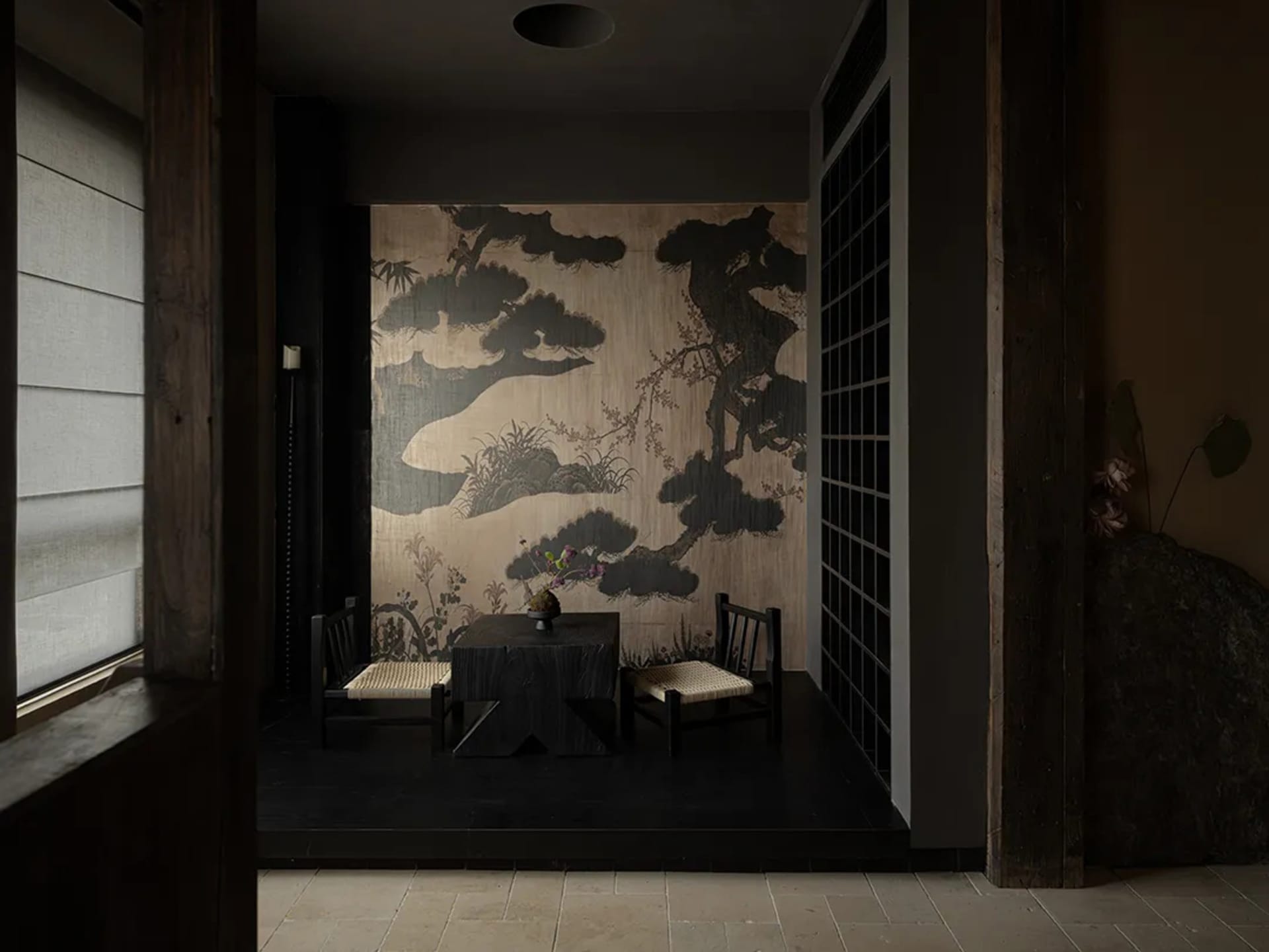 Cozy dining space with Asian-inspired decor, a dining table, chairs, and artwork on the walls, dimly lit for a warm ambiance