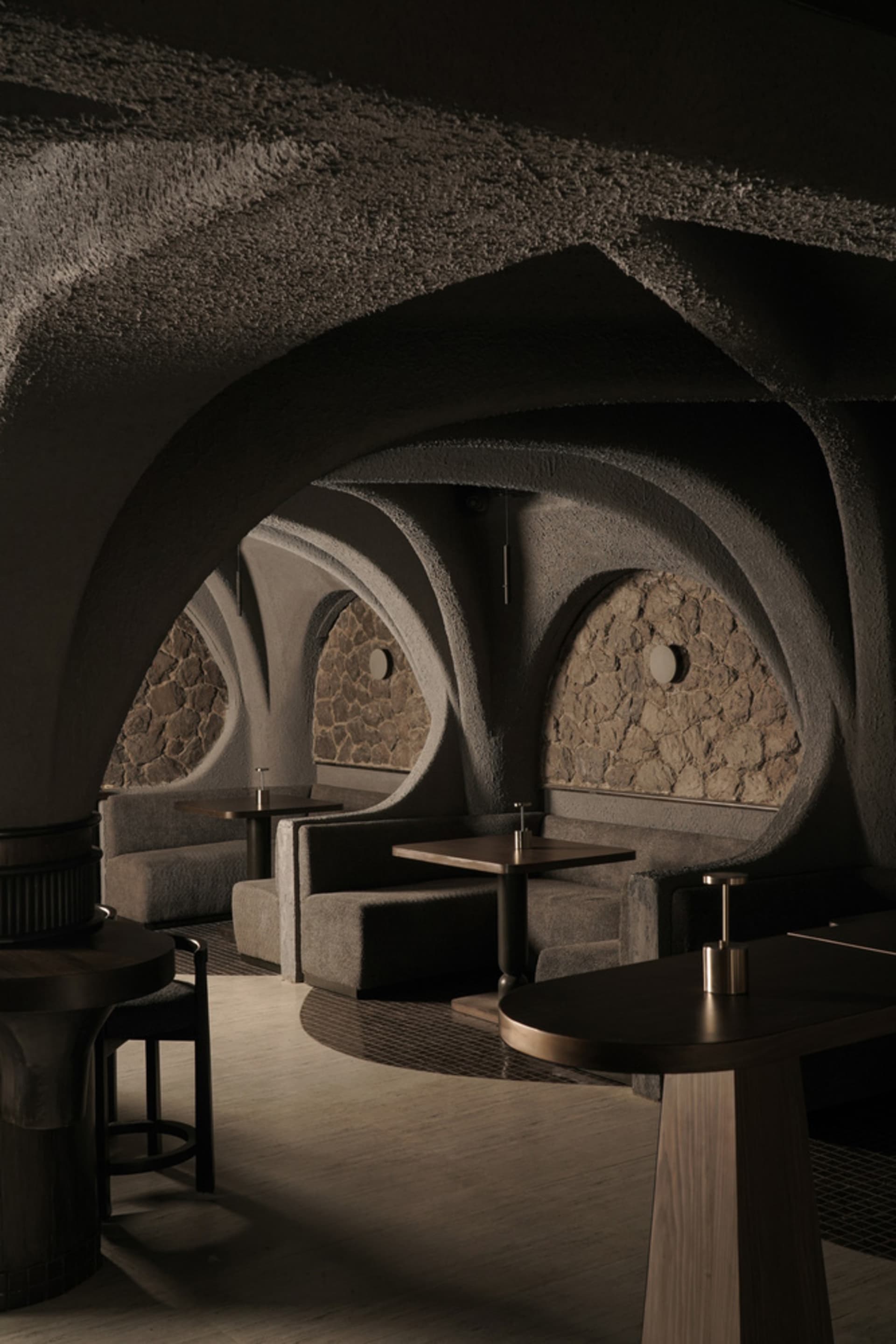 Cozy restaurant interior with stone walls, wooden furniture, and warm lighting