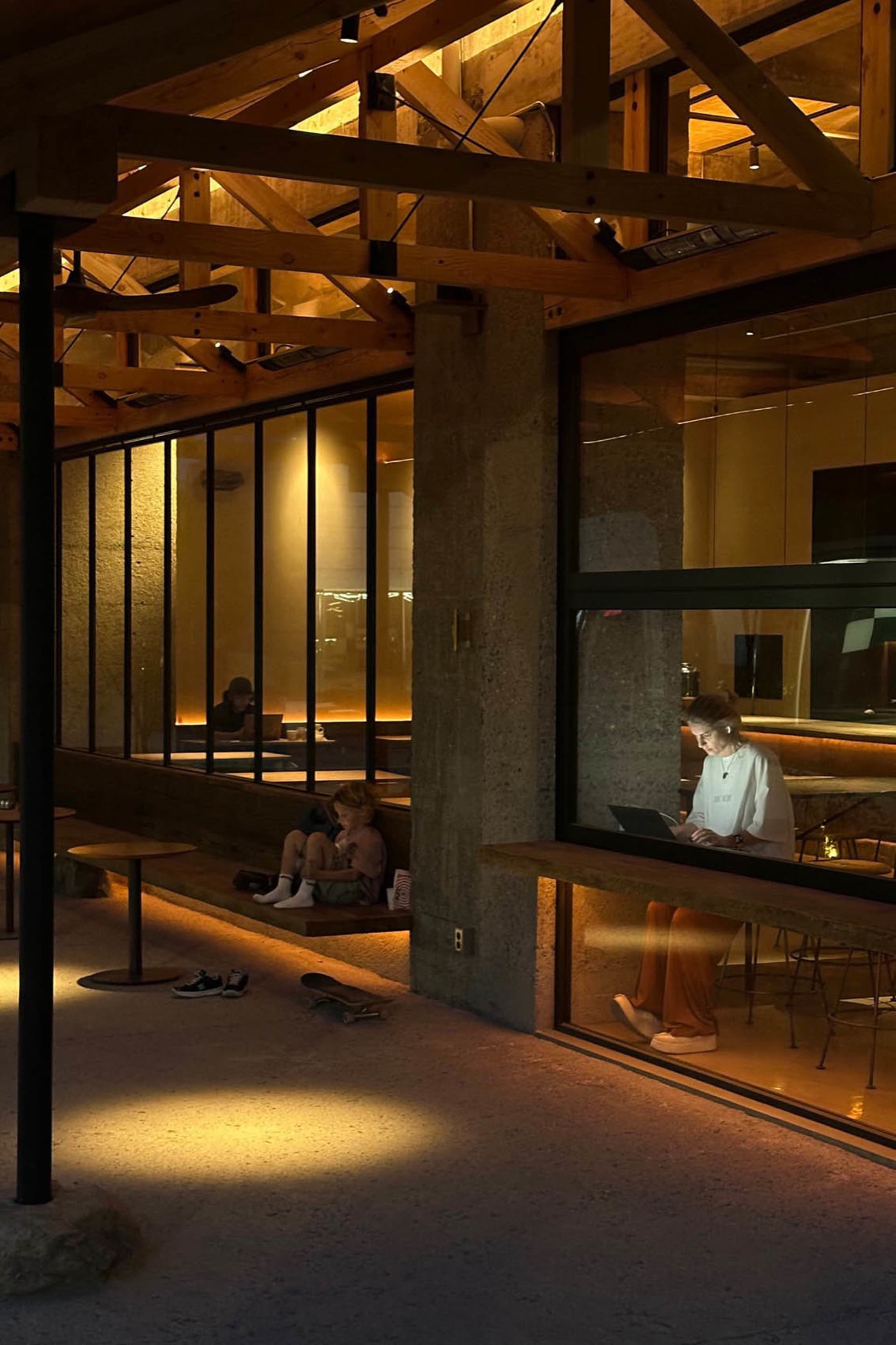 A bustling cafe with people eating, working, and socializing in a modern space with comfortable seating and technology