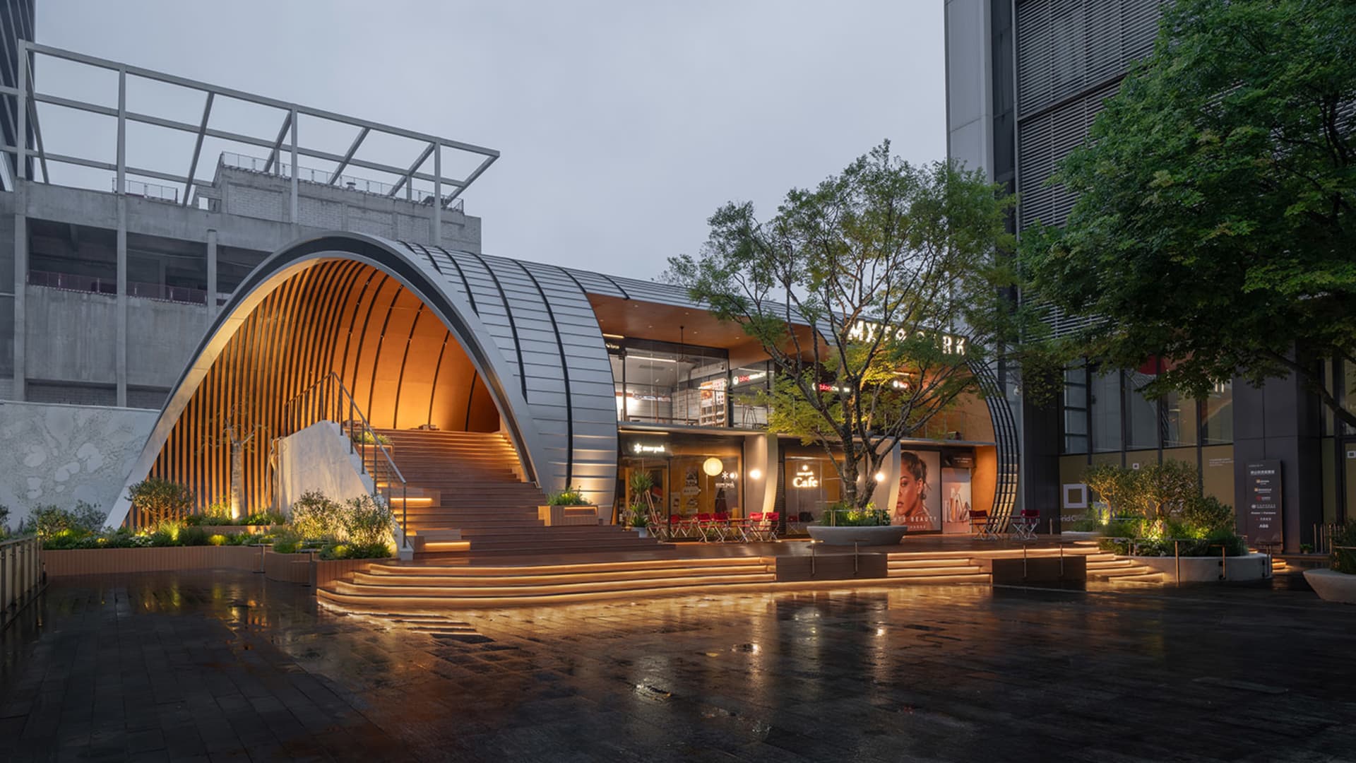 A modern interior space with a large glass wall, comfortable seating area, and natural light