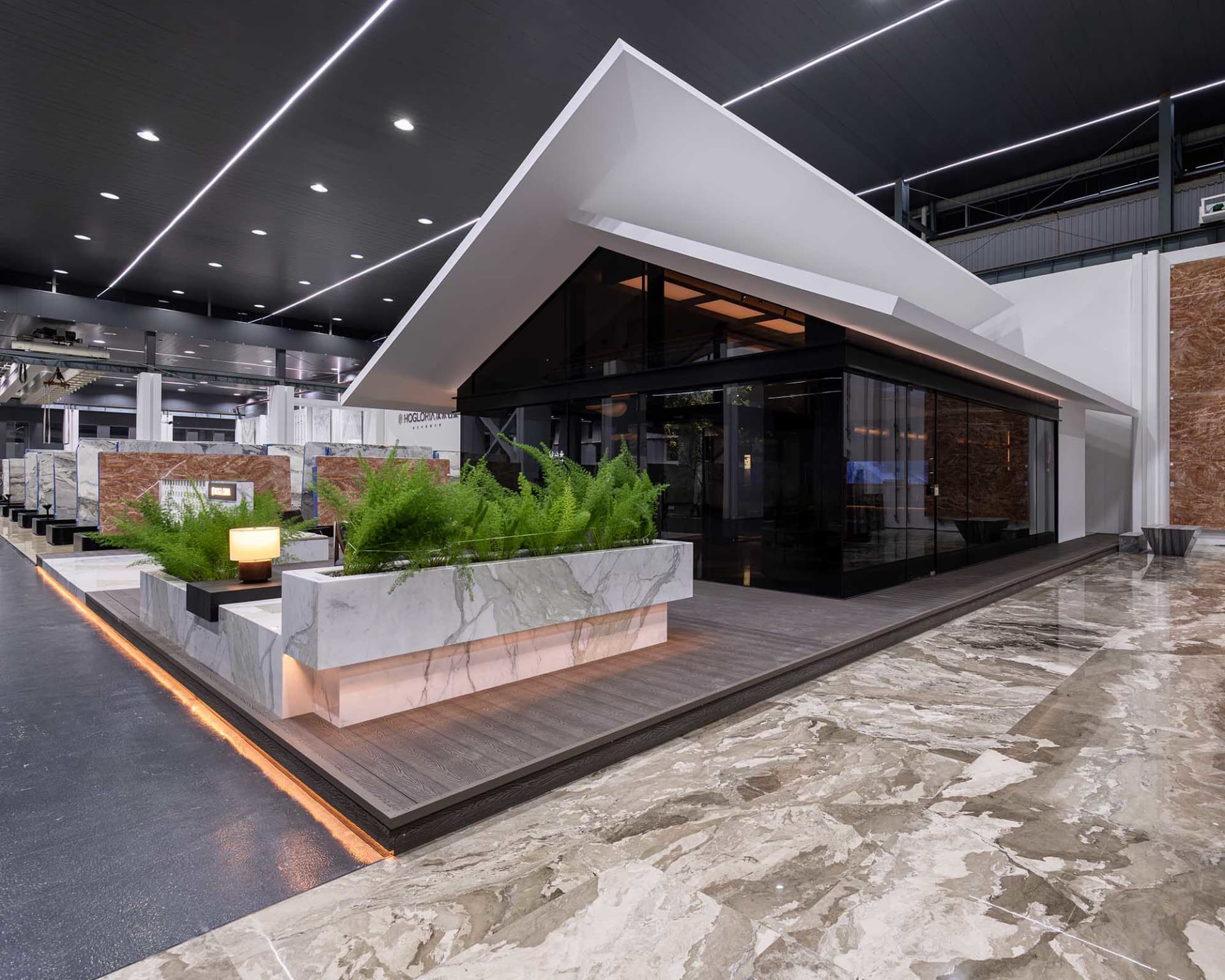 A modern house with a glass wall, potted plants, and two chairs, conveying a sense of contemporary design and comfort