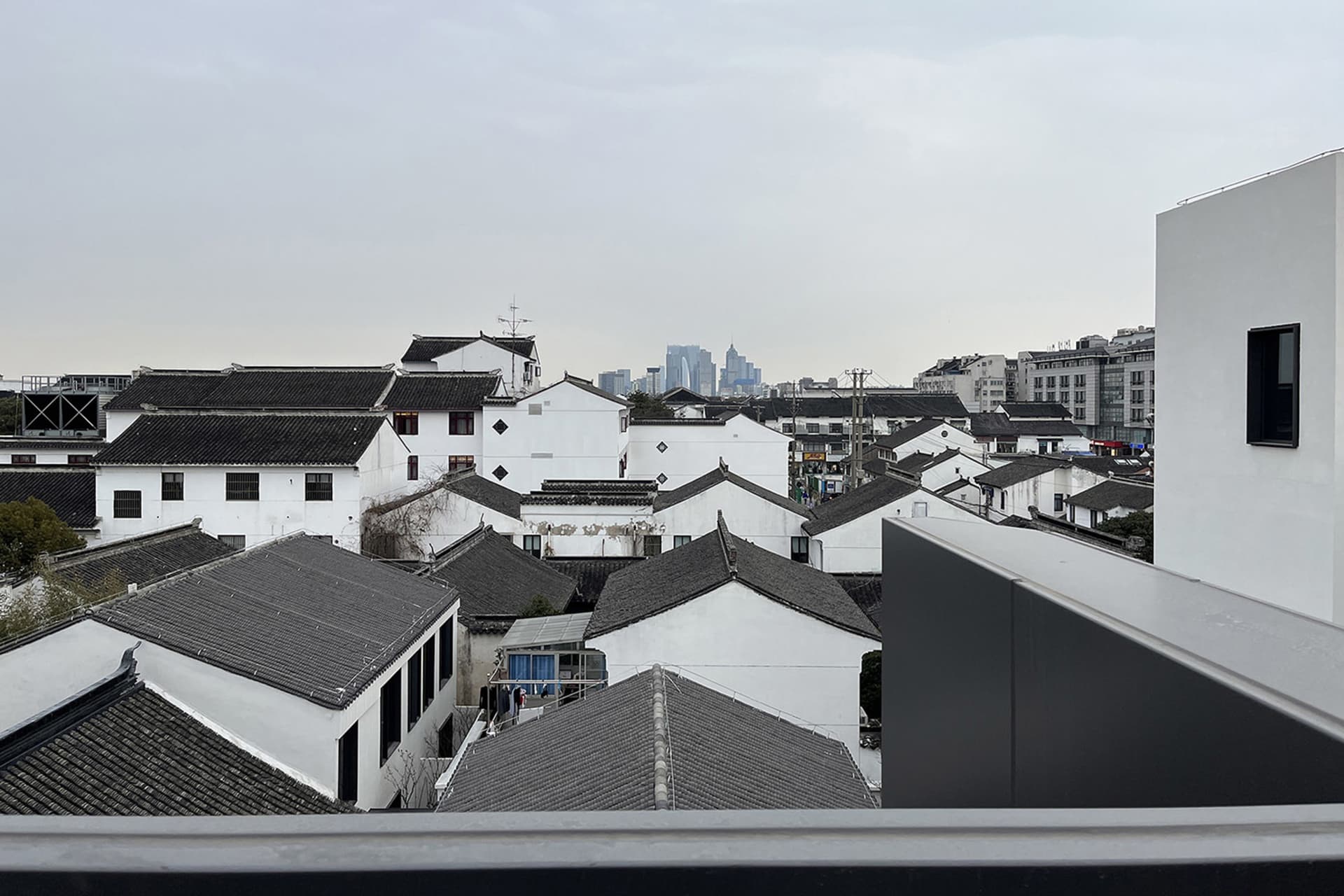 Aerial view of a densely populated city with white buildings, varied roof structures, and a vibrant atmosphere