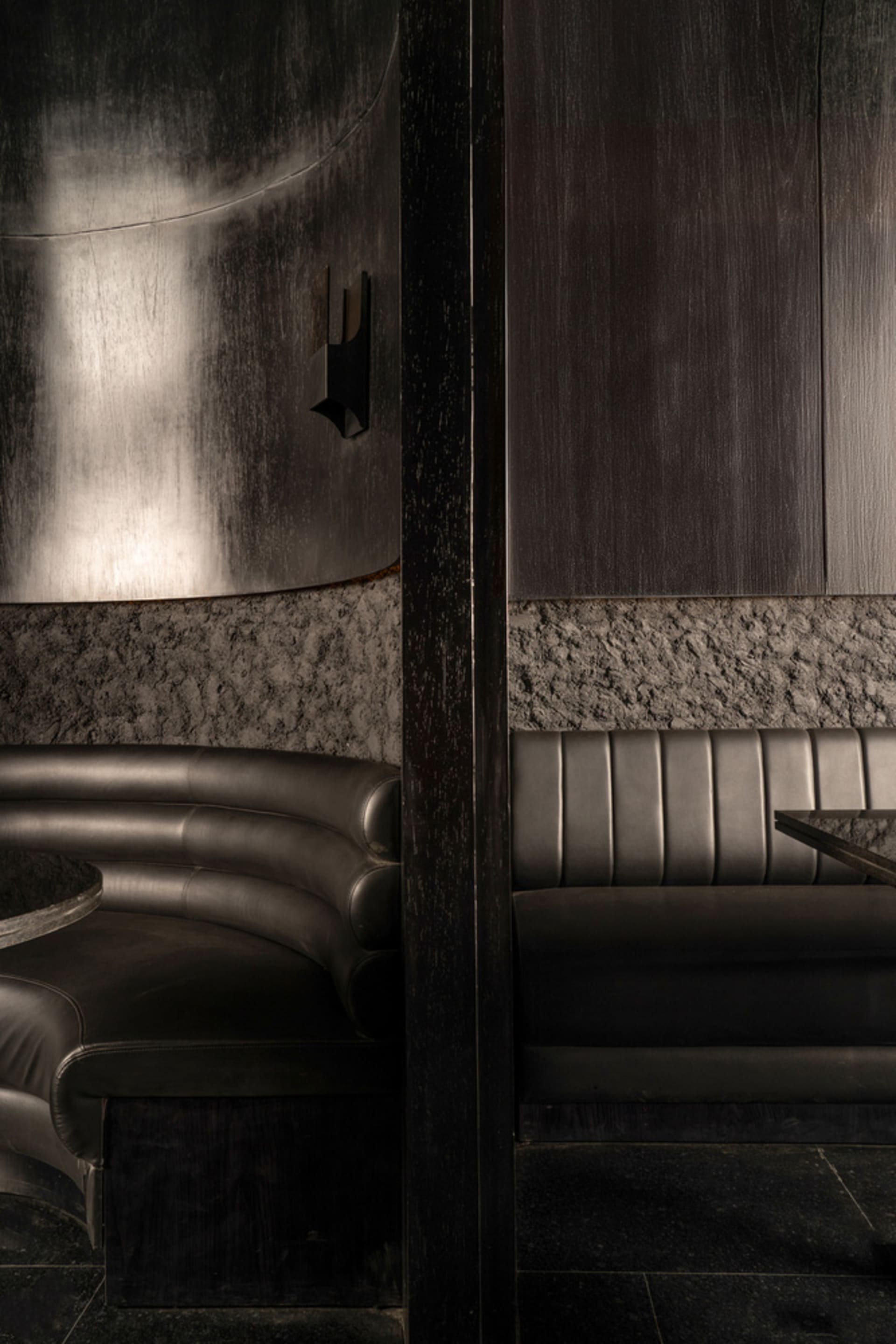 Modern living space with two black leather couches, two chairs, and a stylish atmosphere