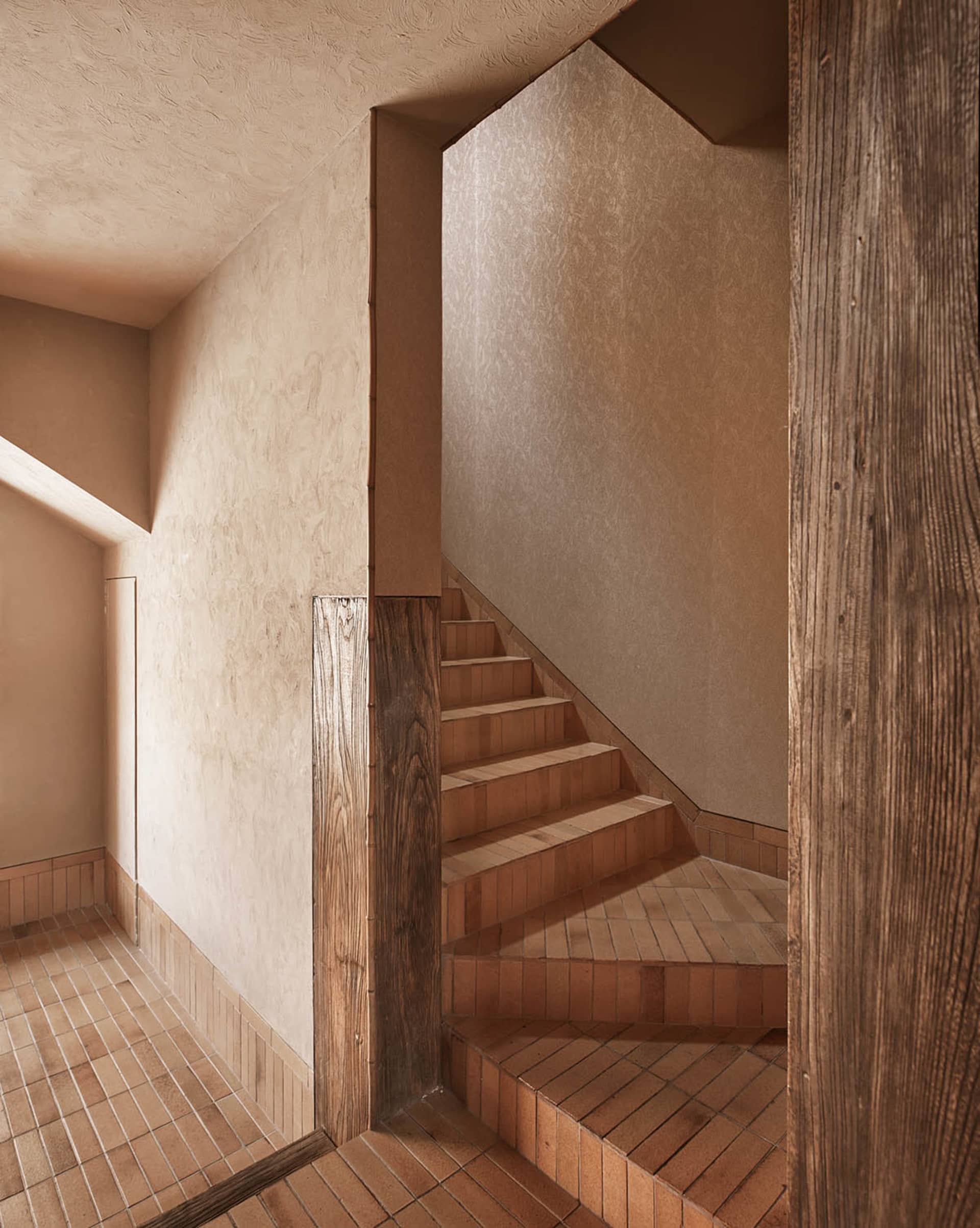 A warm and inviting wooden staircase with brown treads and risers, set against a neutral background