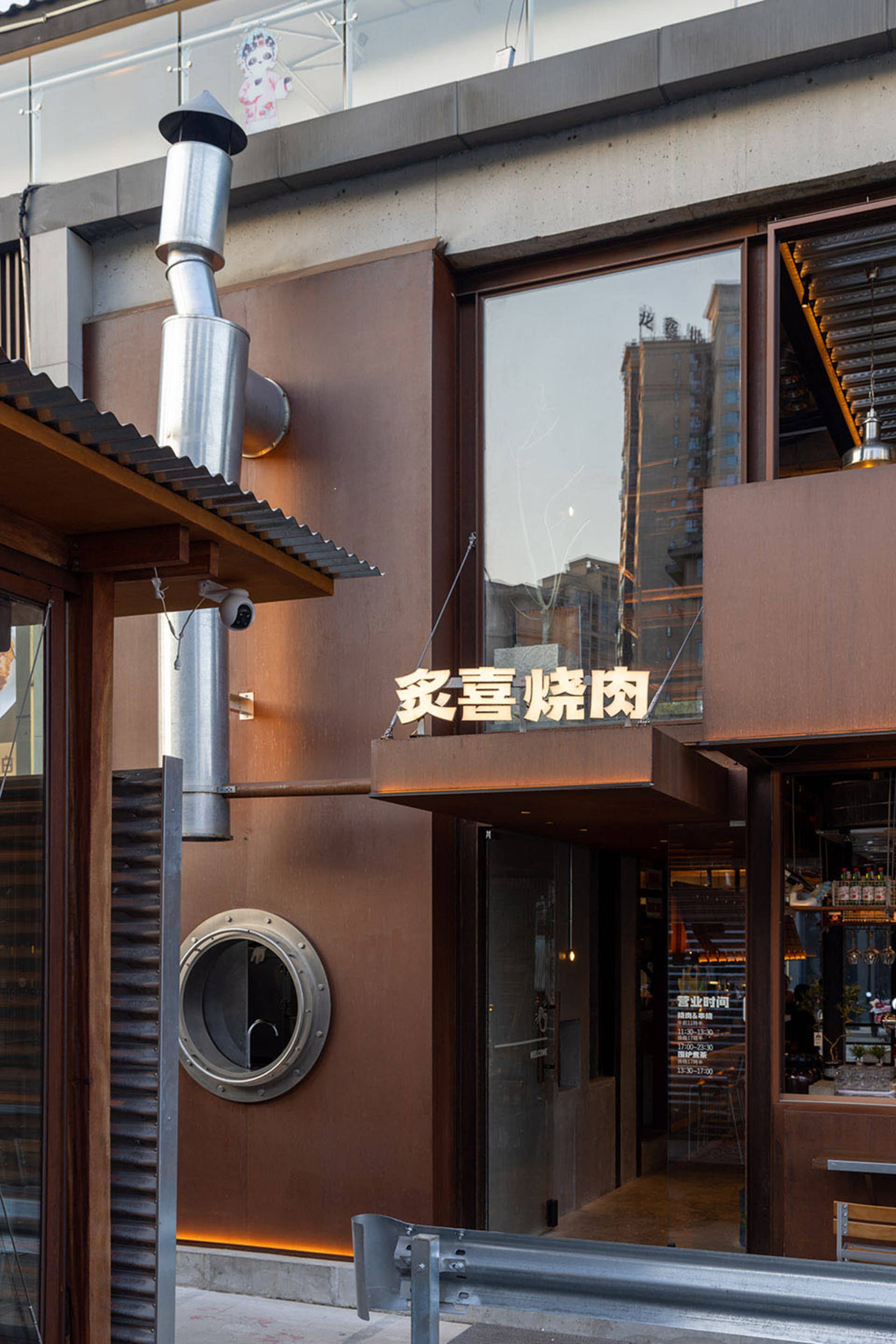 Exterior view of an Asian restaurant with a brown facade, large window, and modern yet warm architecture featuring wood and metal elements
