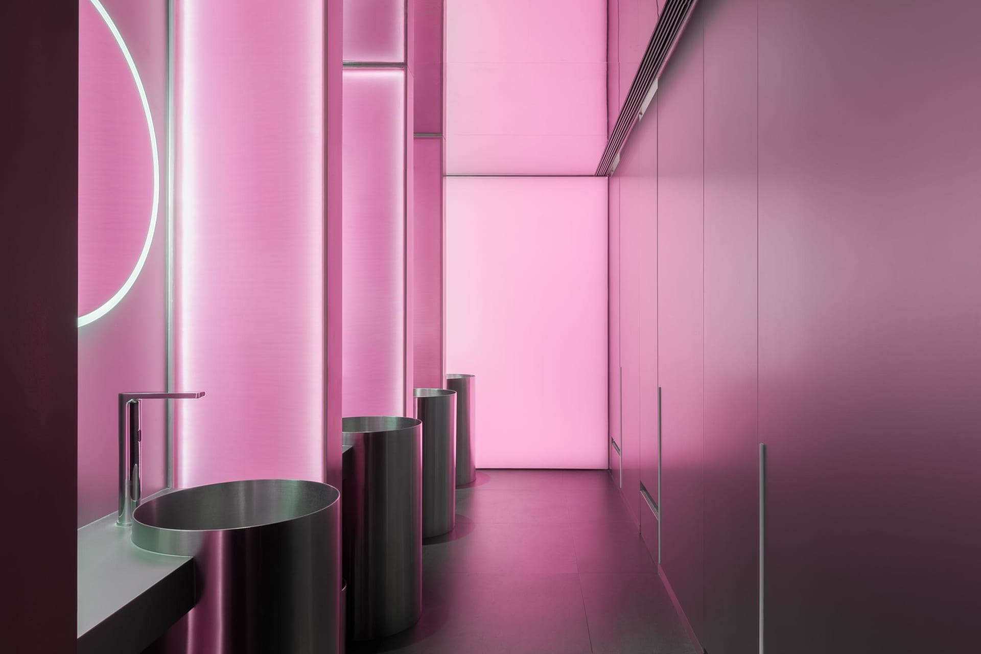 Pink bathroom with silver trash cans and modern minimalist design