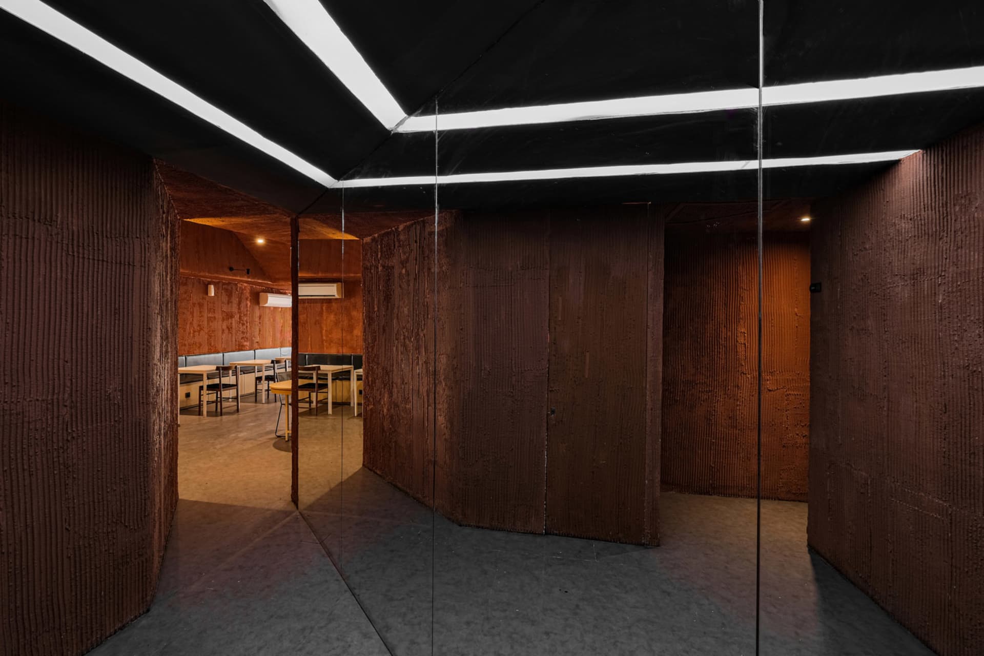 A warm and inviting room with wooden walls and floors, featuring a dining table and chairs, creating a cozy atmosphere