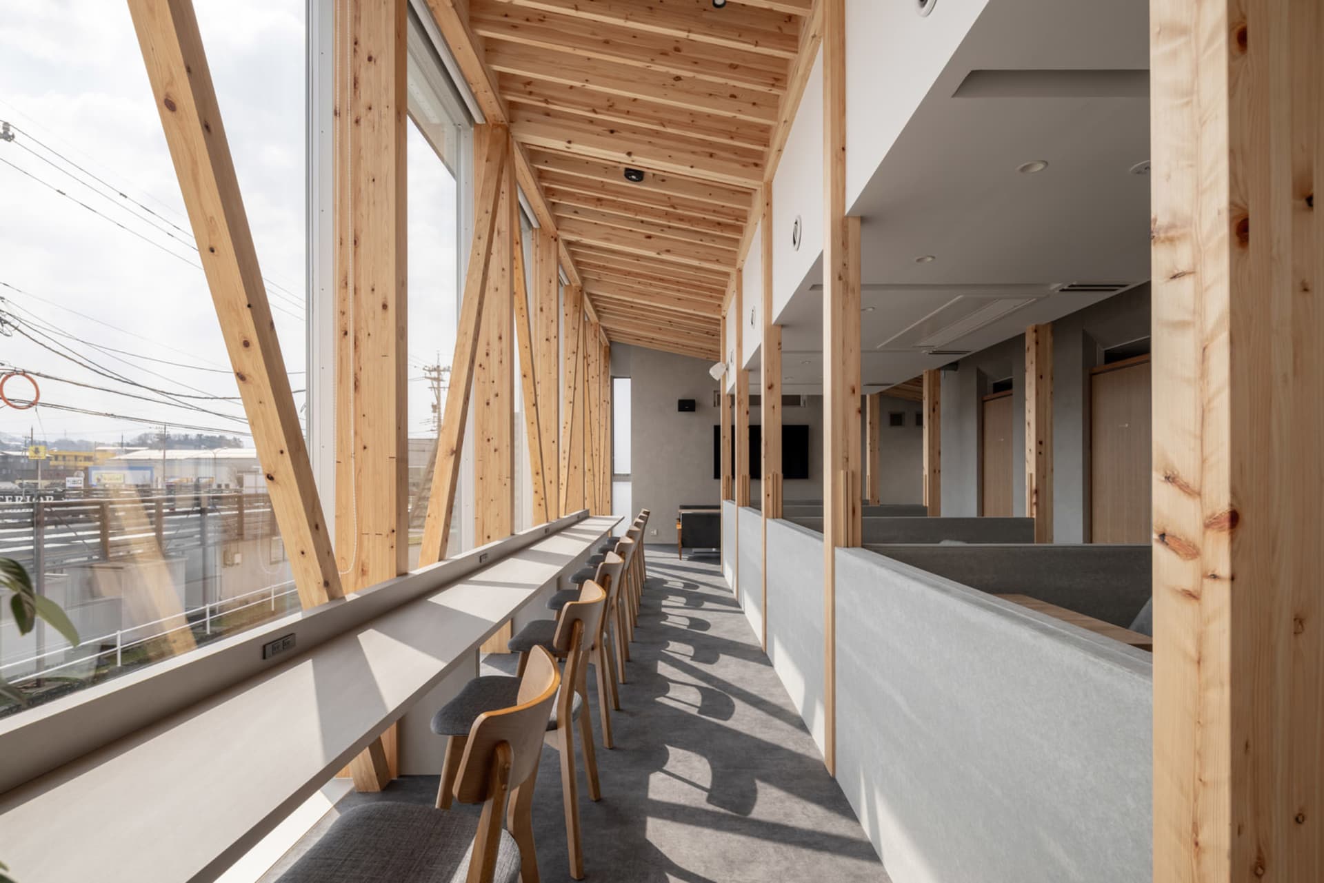 A large dining hall with wooden beams, high ceilings, and various chairs, creating a warm and inviting atmosphere