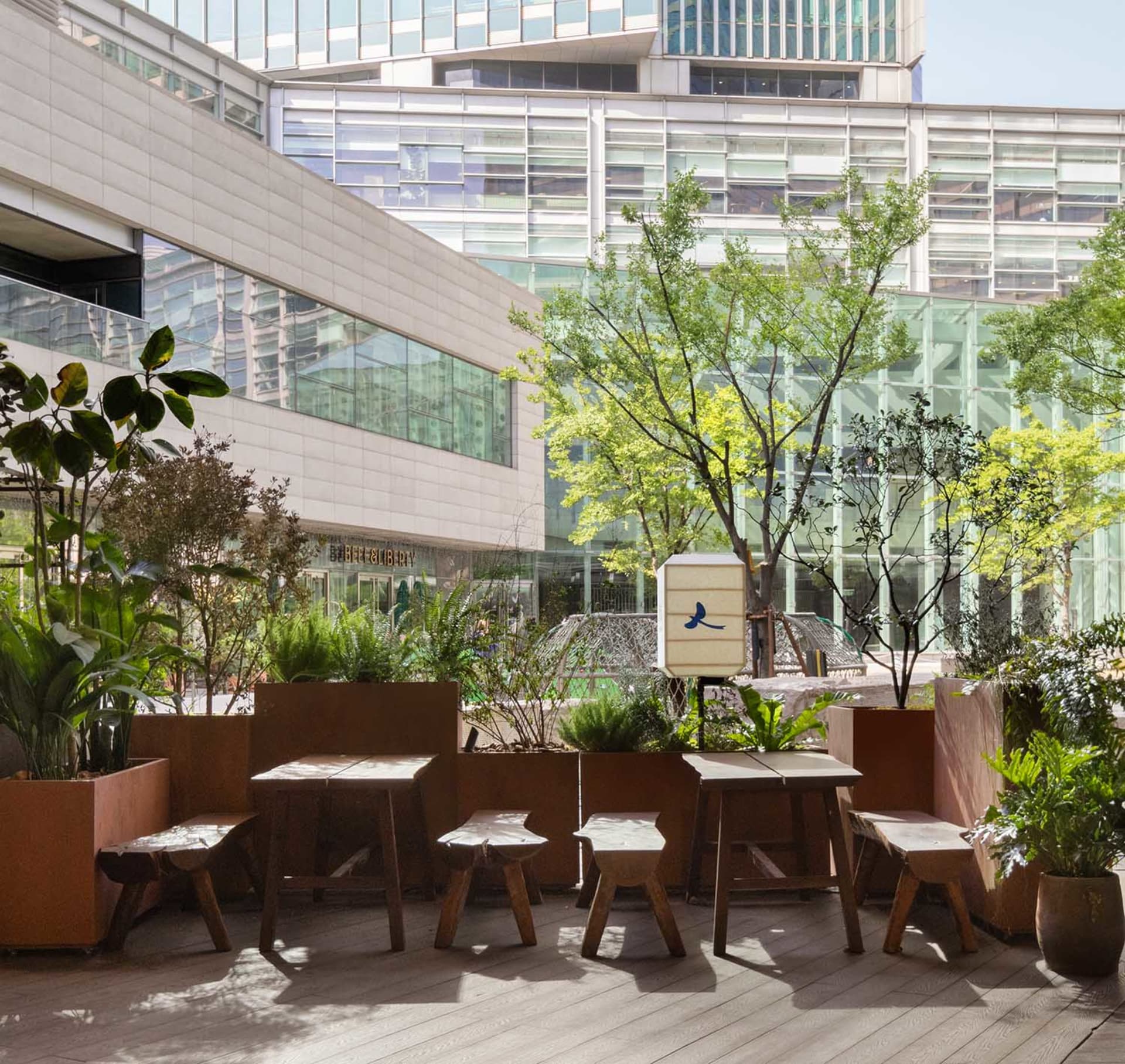 A casual outdoor patio with multiple wooden tables and chairs, perfect for socializing and enjoying meals or conversations