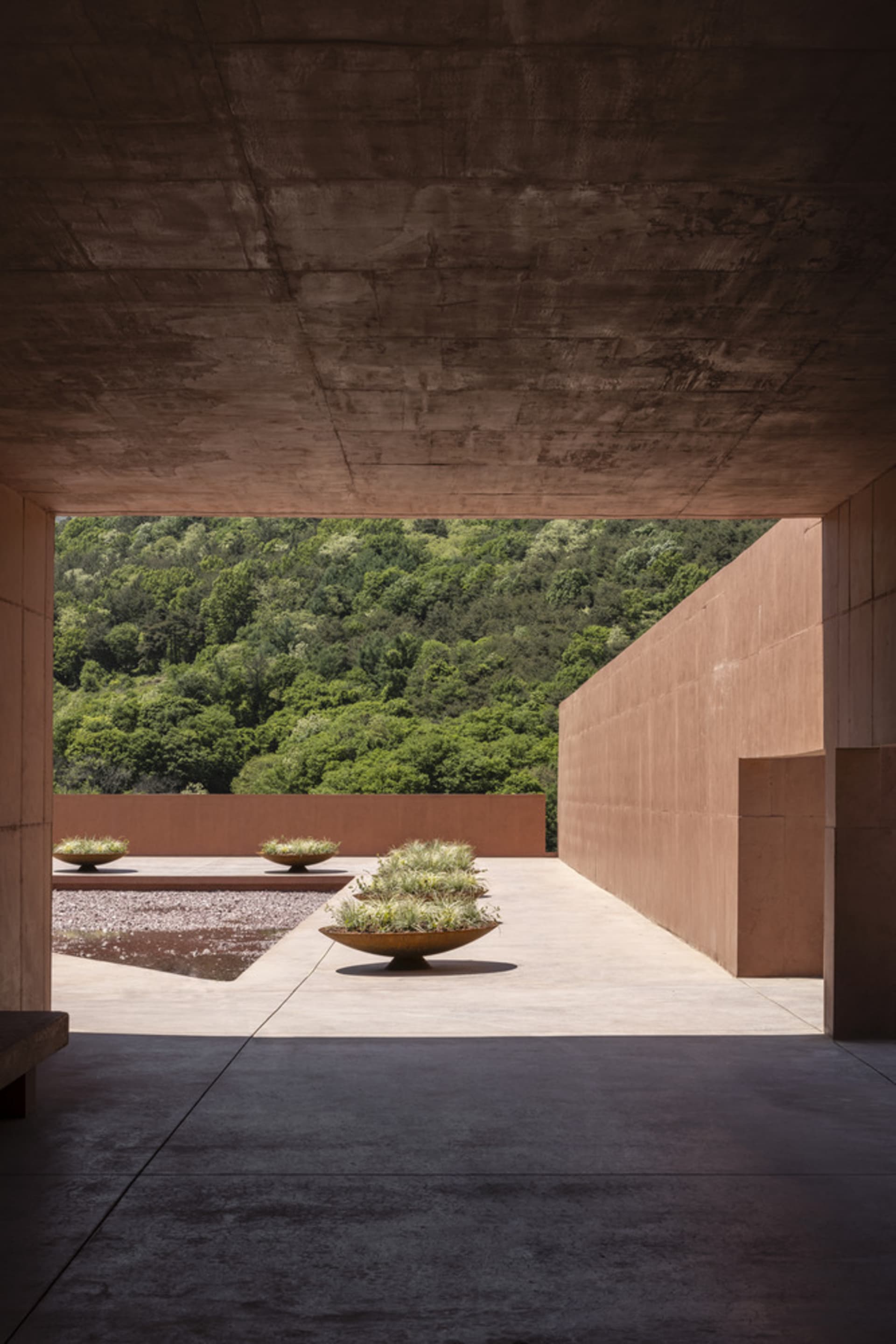 A grand building with a stone facade, featuring three vases on the ground outside, adding to its aesthetic appeal