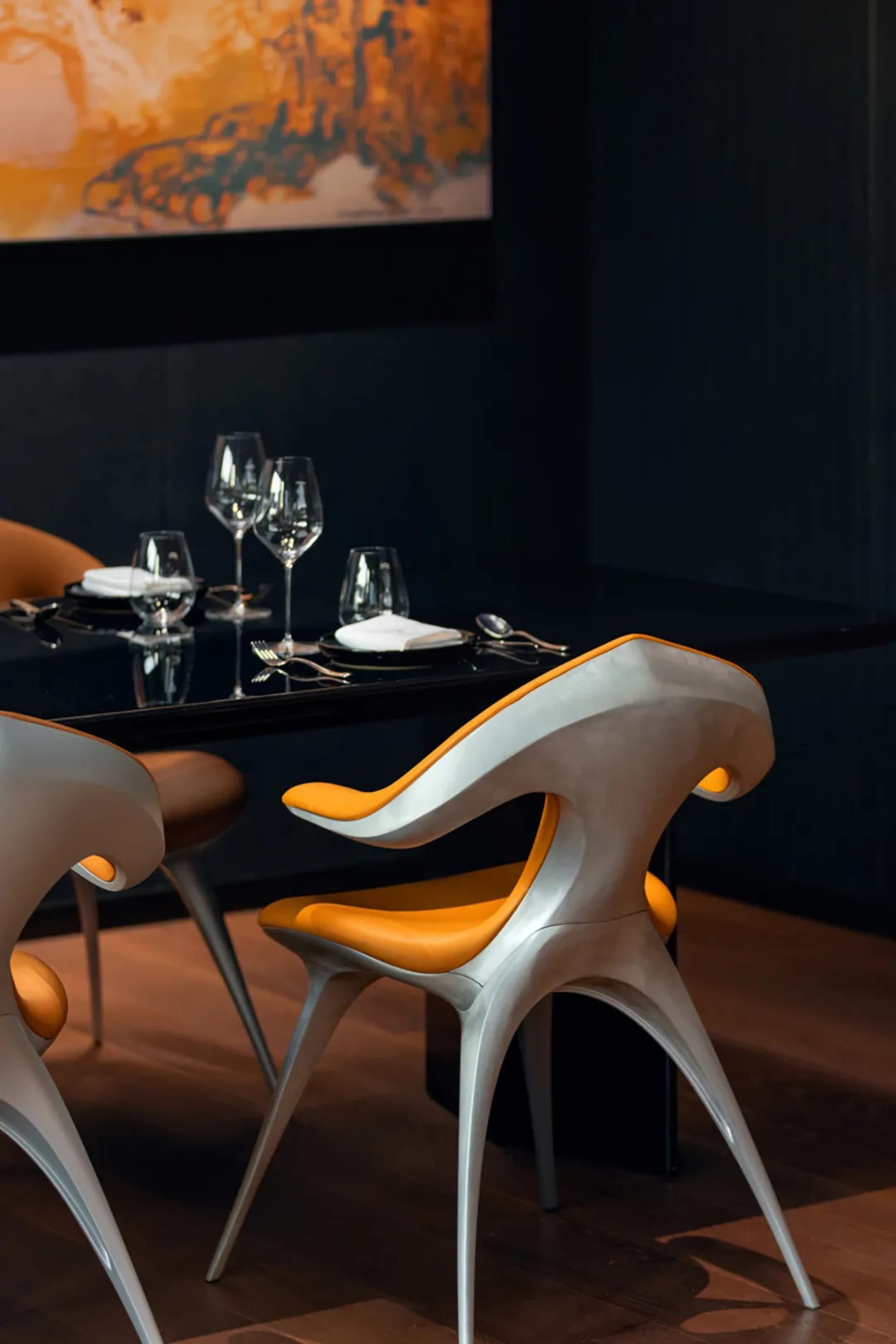 Elegant dining area with a black table, leather chairs, and fine china and cutlery