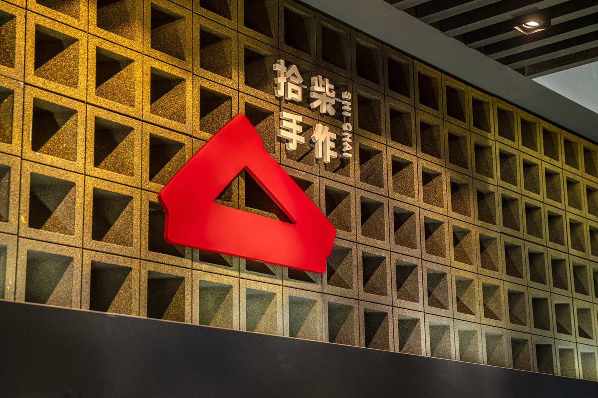 Modern Asian building with a red metal sign and a combination of stone and metal exterior elements