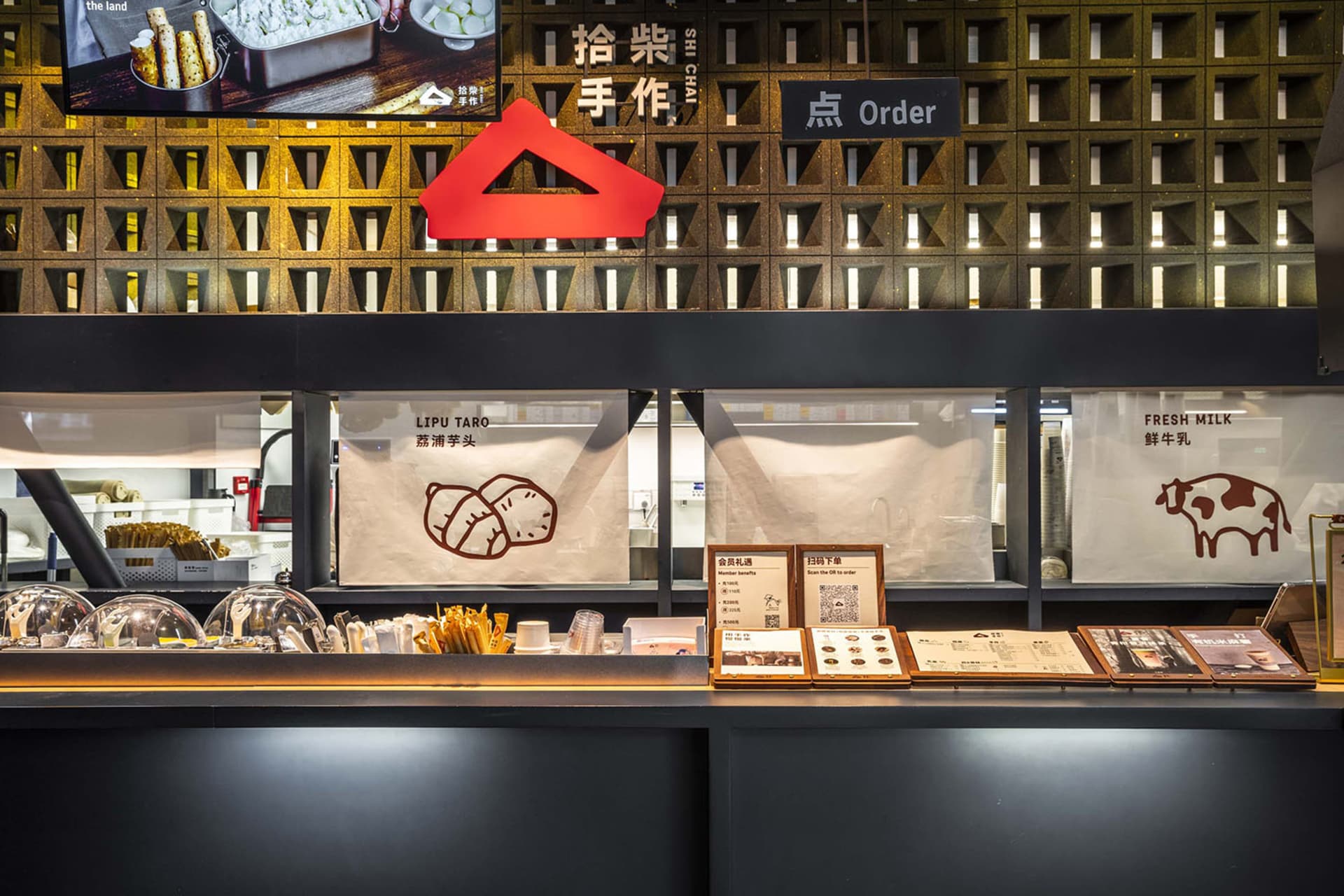 現代餐廳配黑色檯面、紅色三角圖形，以及各式展示美食