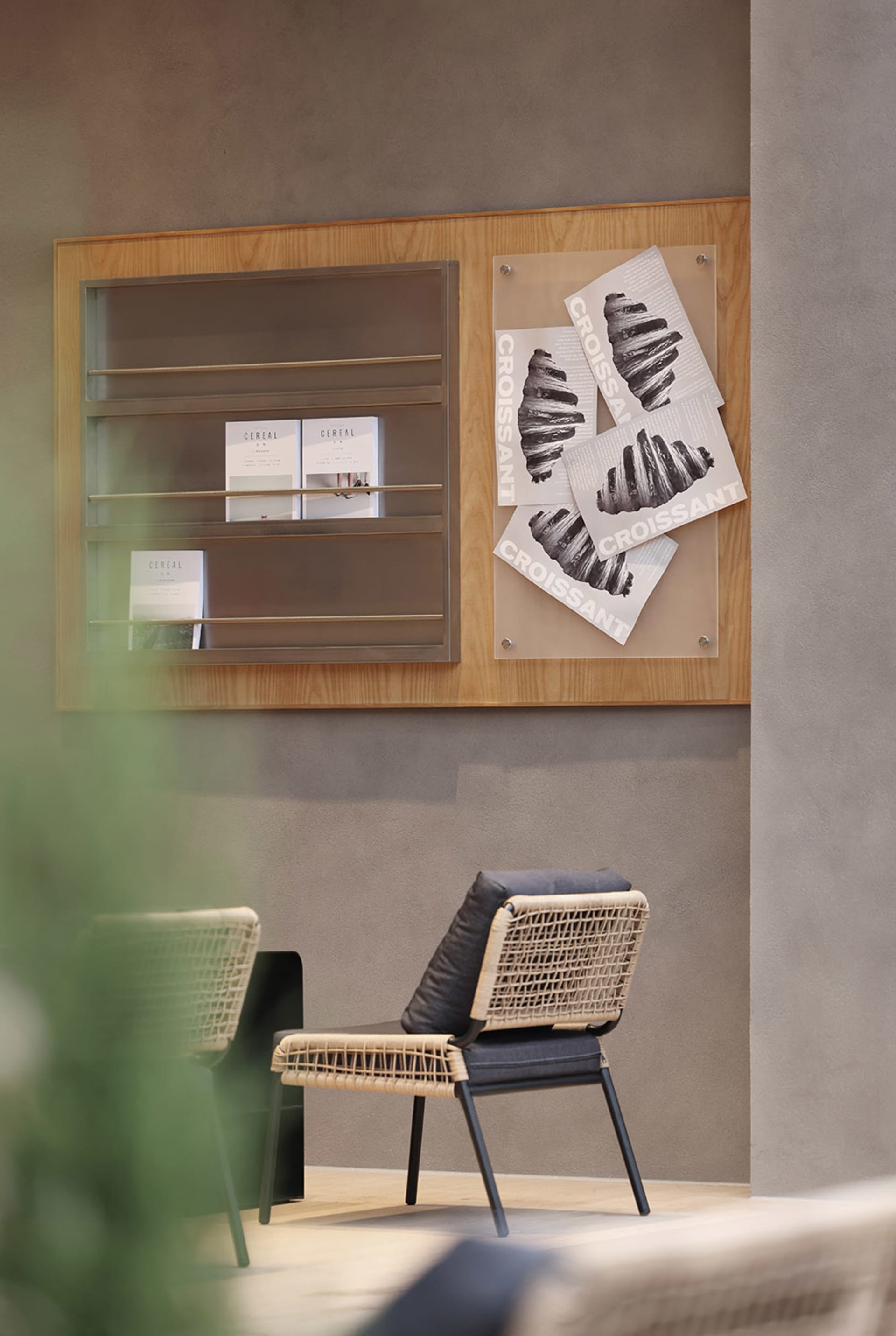 A cozy living space with a woven chair, a wooden couch, and two books, suggesting a warm and inviting atmosphere