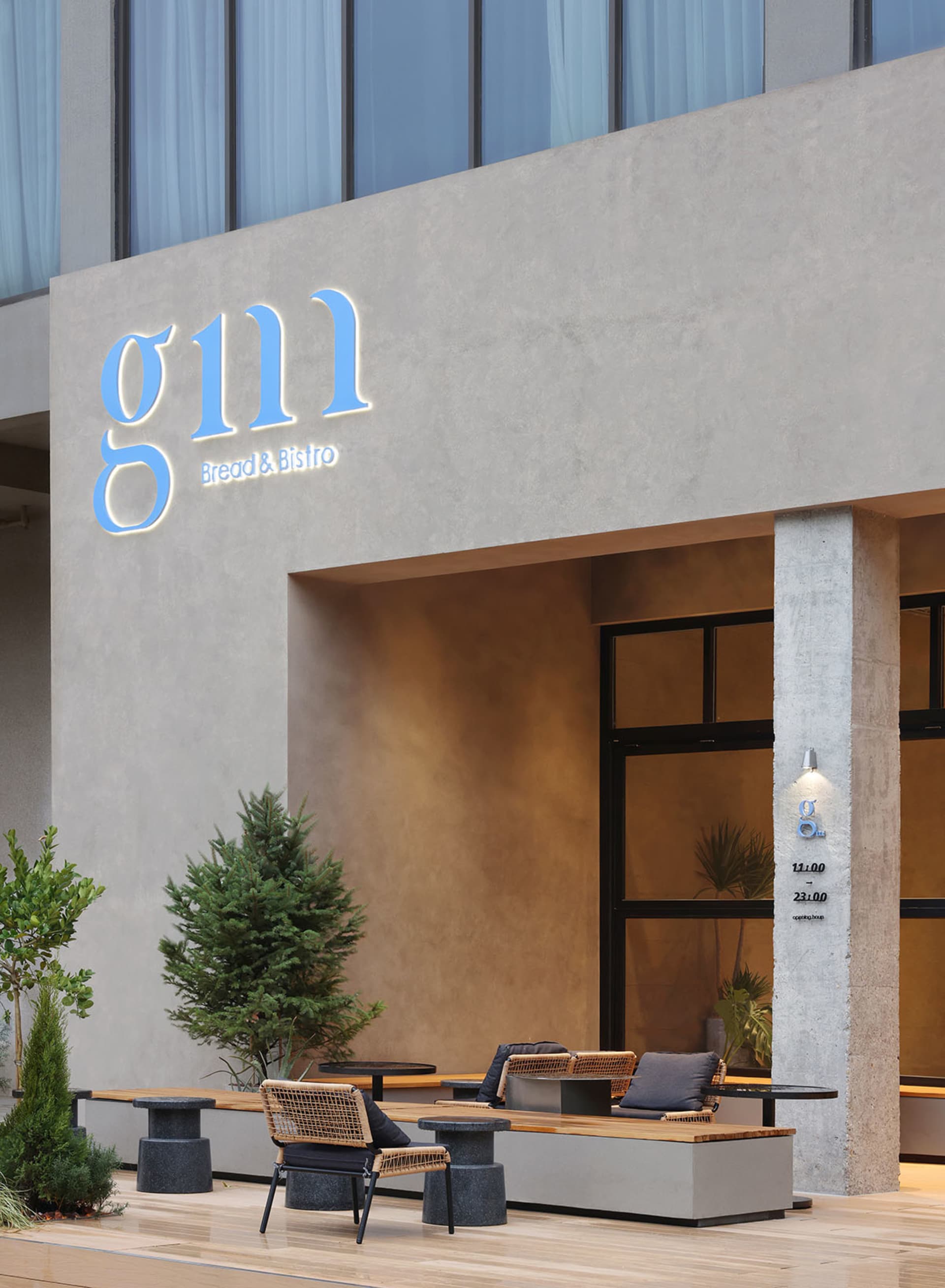 An inviting outdoor seating area with wrought iron chairs and a dining table near a building, surrounded by lush greenery