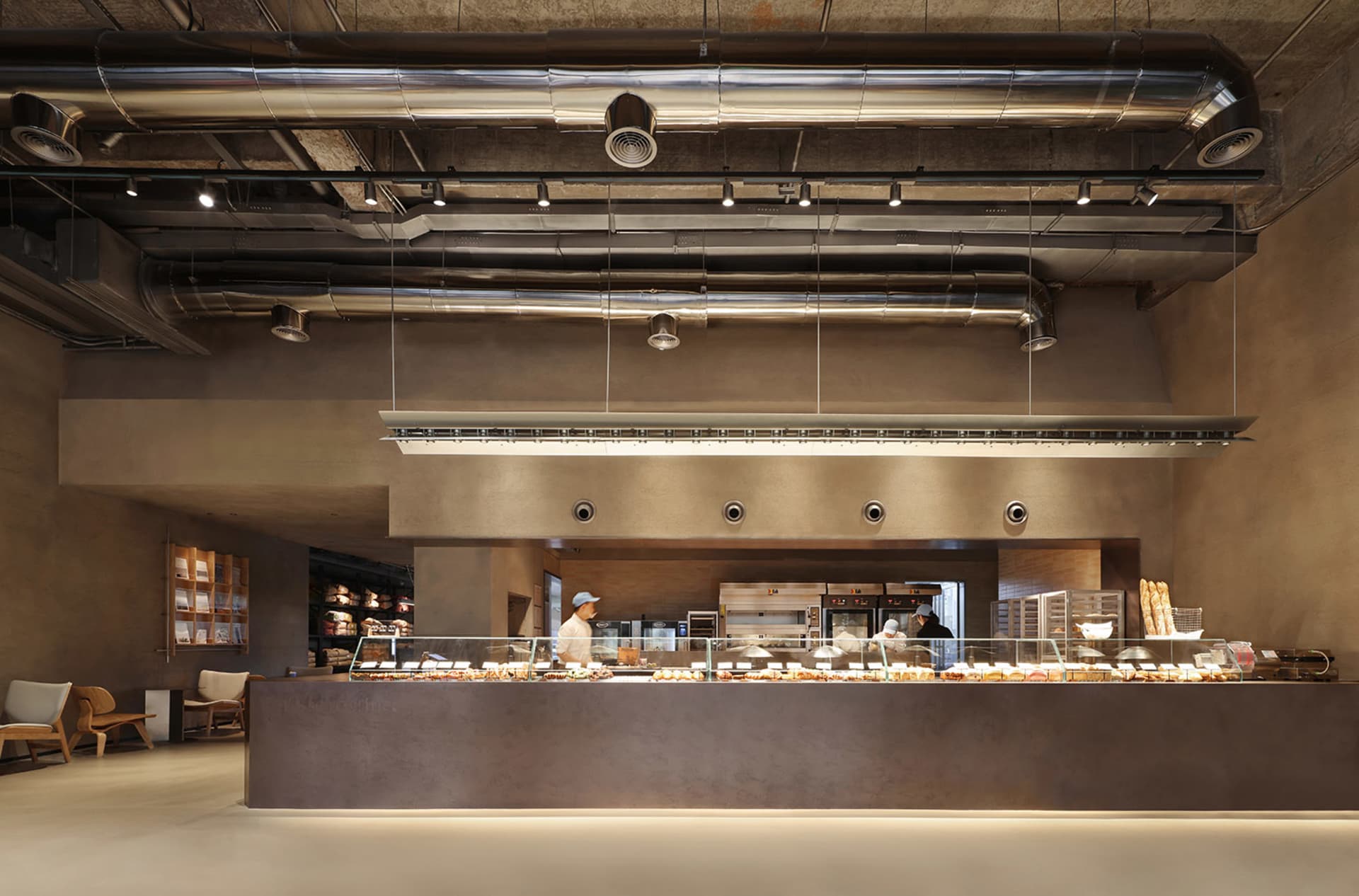 A bustling restaurant kitchen with people, food, and kitchen utensils, set against a background of kitchen equipment and storage