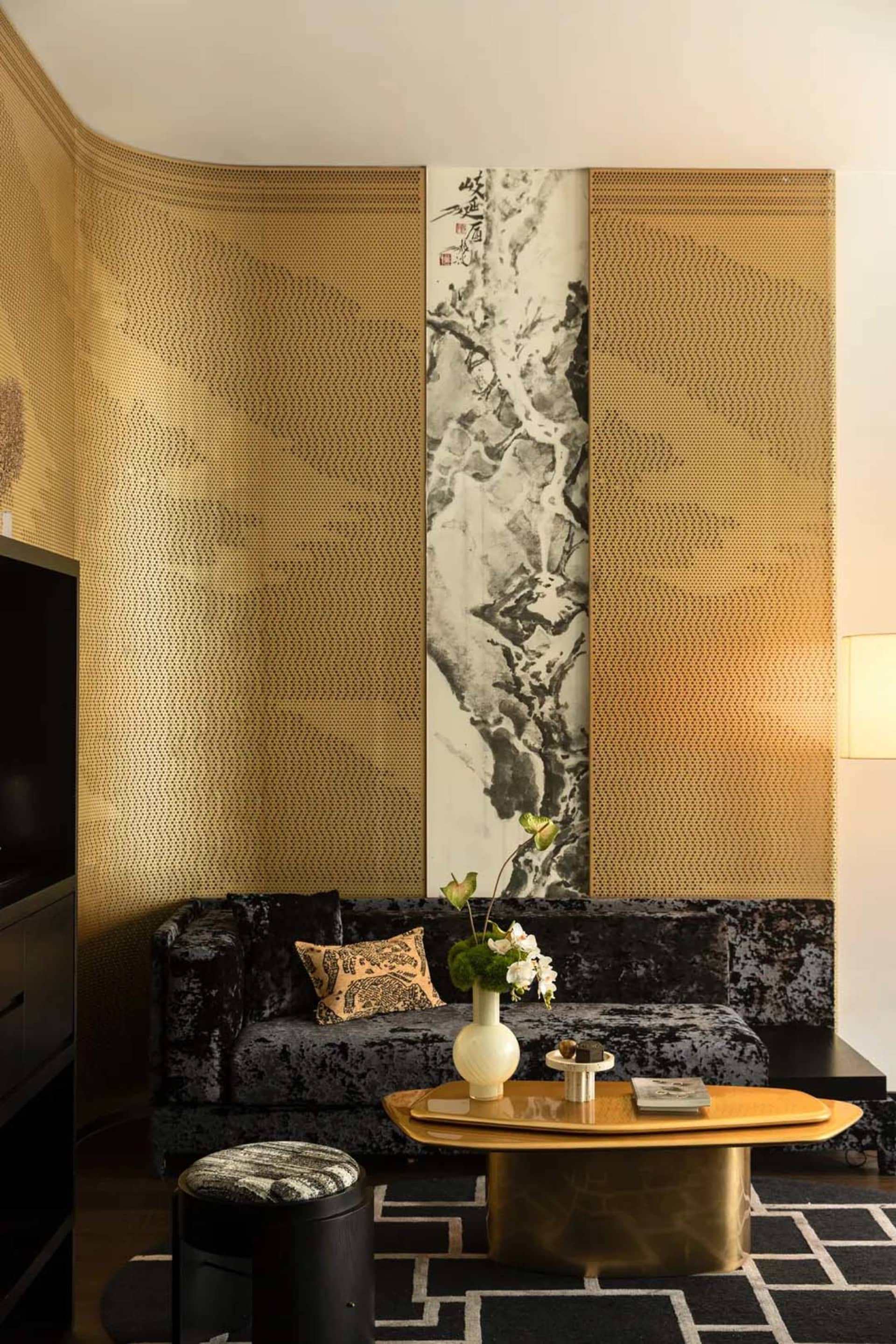 Cozy living area with a couch, a large painting on the wall, and decorative vases on a table