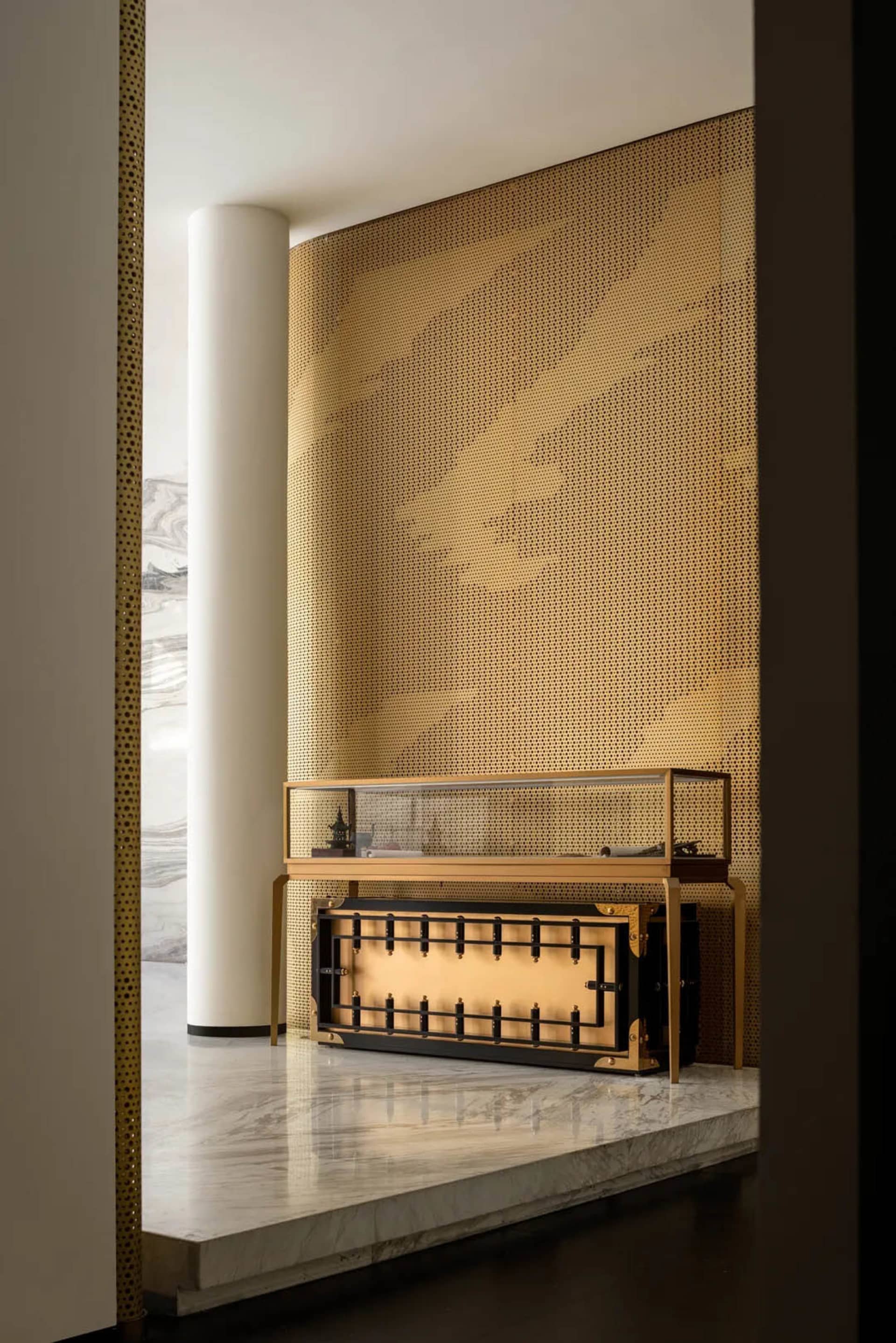 Elegant workspace with a large wooden desk, glass countertop, and a unique patterned paper covering on the wall
