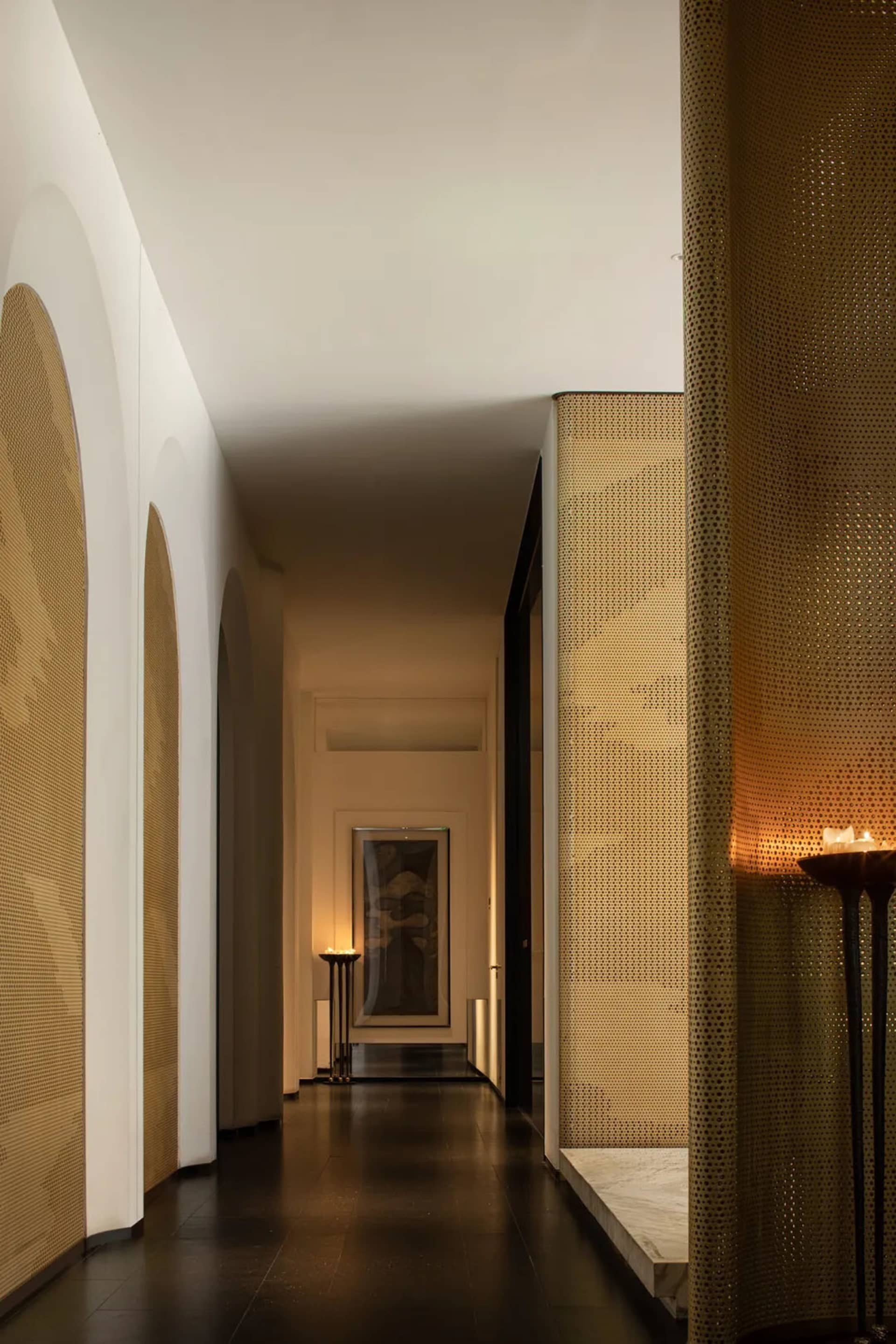 A dimly lit hallway with a patterned wall, two doors, and a mysterious atmosphere