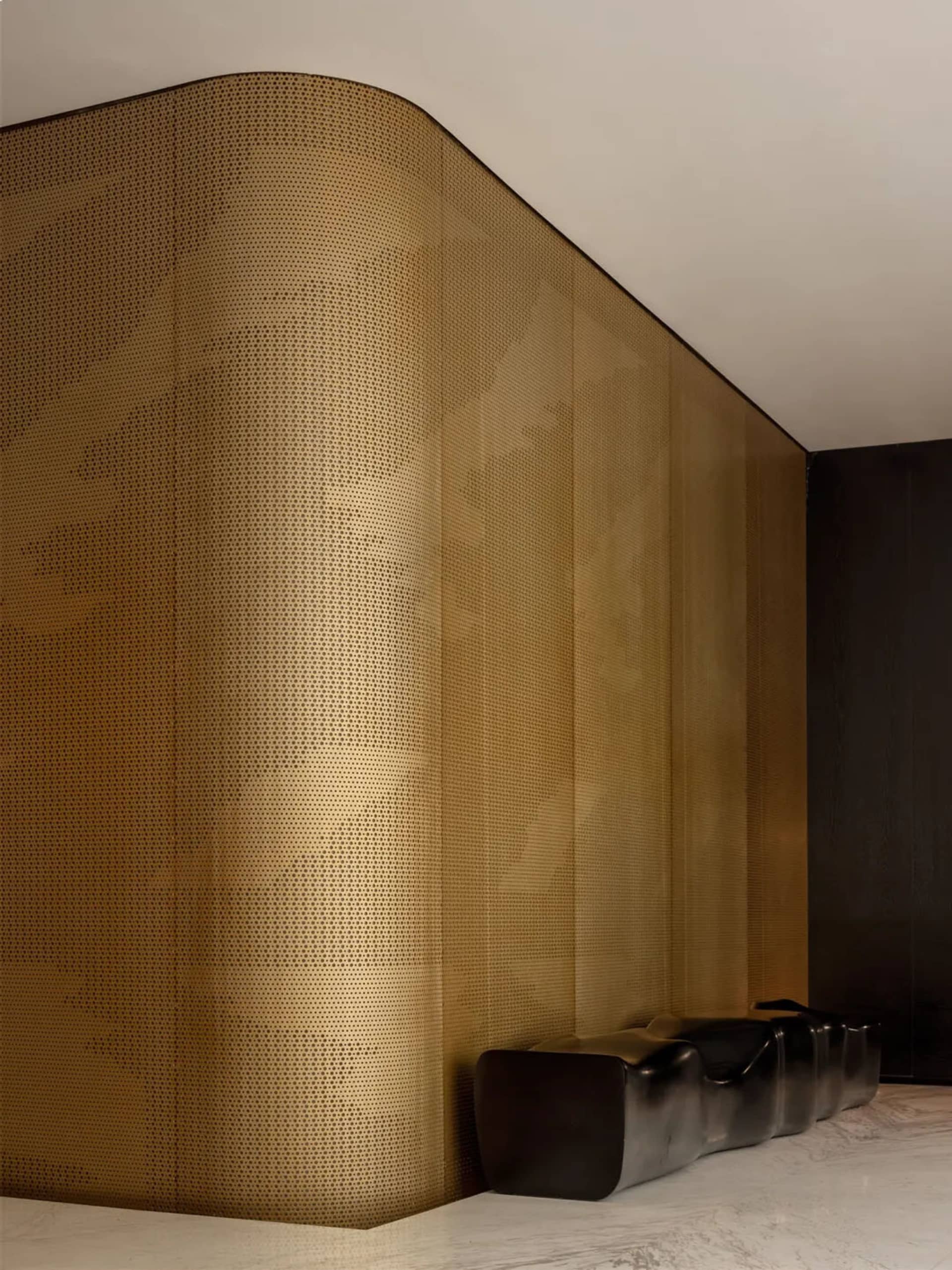 Modern living room with gold wallpaper, two couches, a chair, and a sophisticated atmosphere
