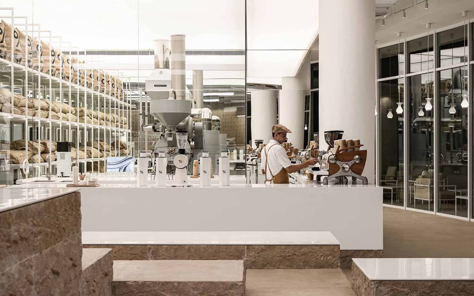 Industrial kitchen with various machines and equipment, two people present, and a large machine as the main focus