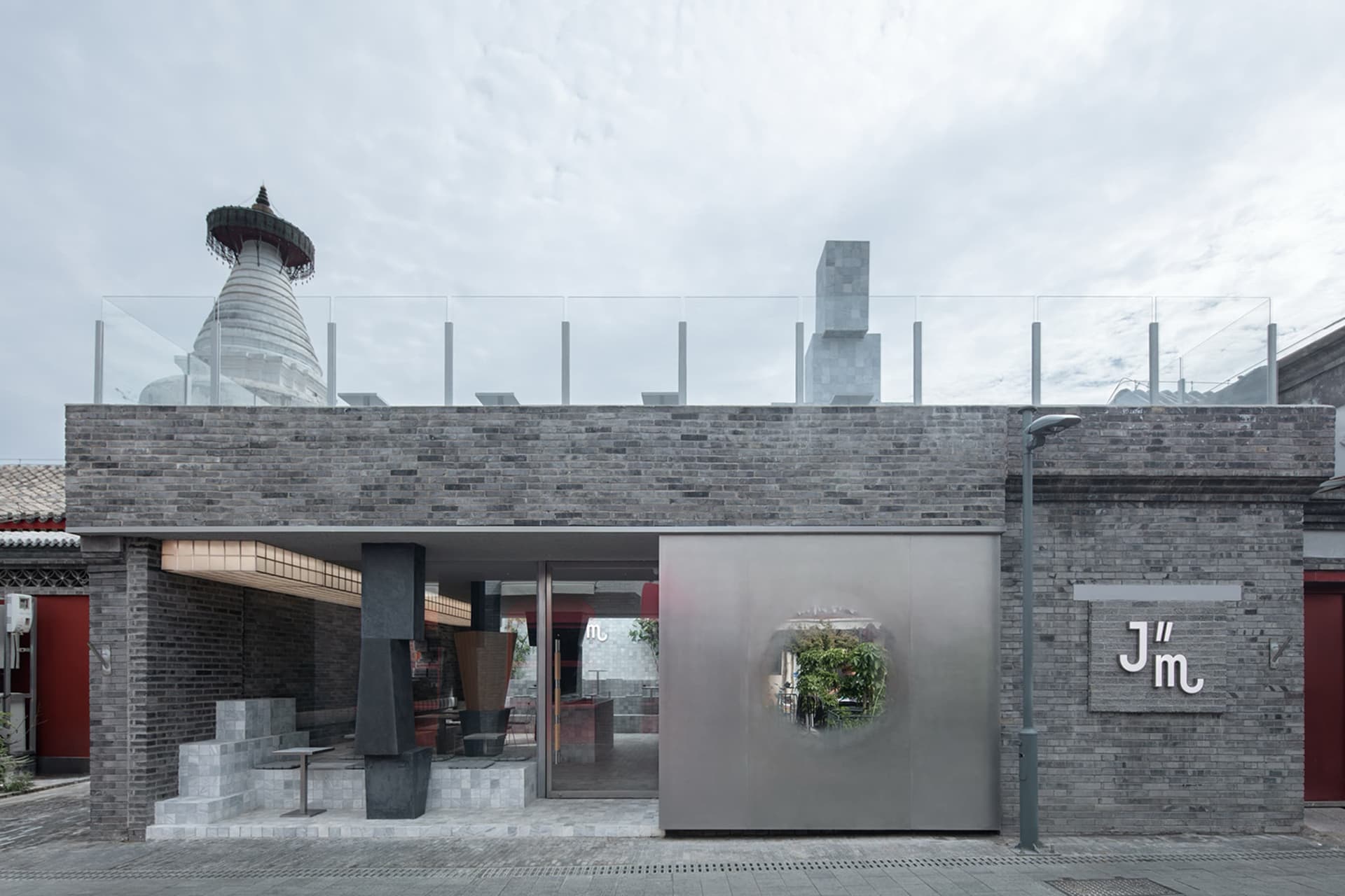 A classic building with a glass dome on its roof, surrounded by brick walls and decorated with potted plants, conveying elegance and sophistication